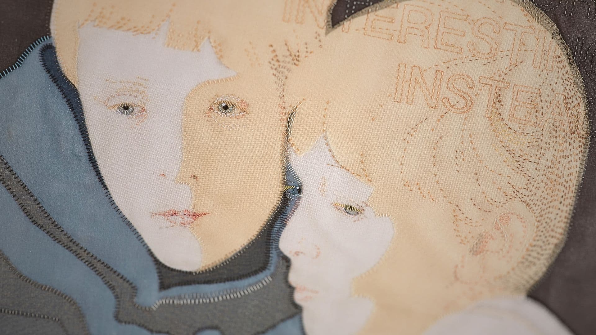 A textile artwork of two boys made with various fabrics and techniques.