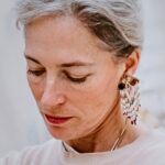 A close up Image of textile artist Emma Cassi and a large beaded earring
