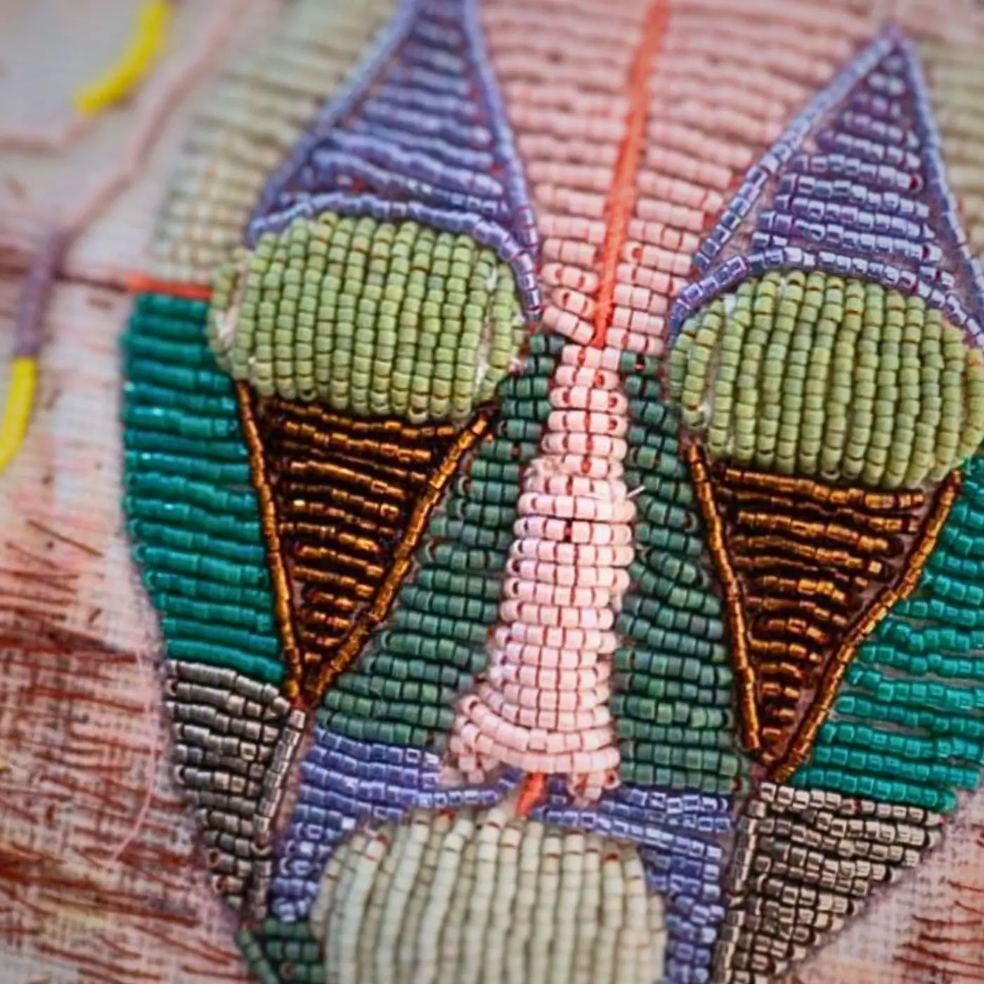 A close up of a beaded stitched portrait