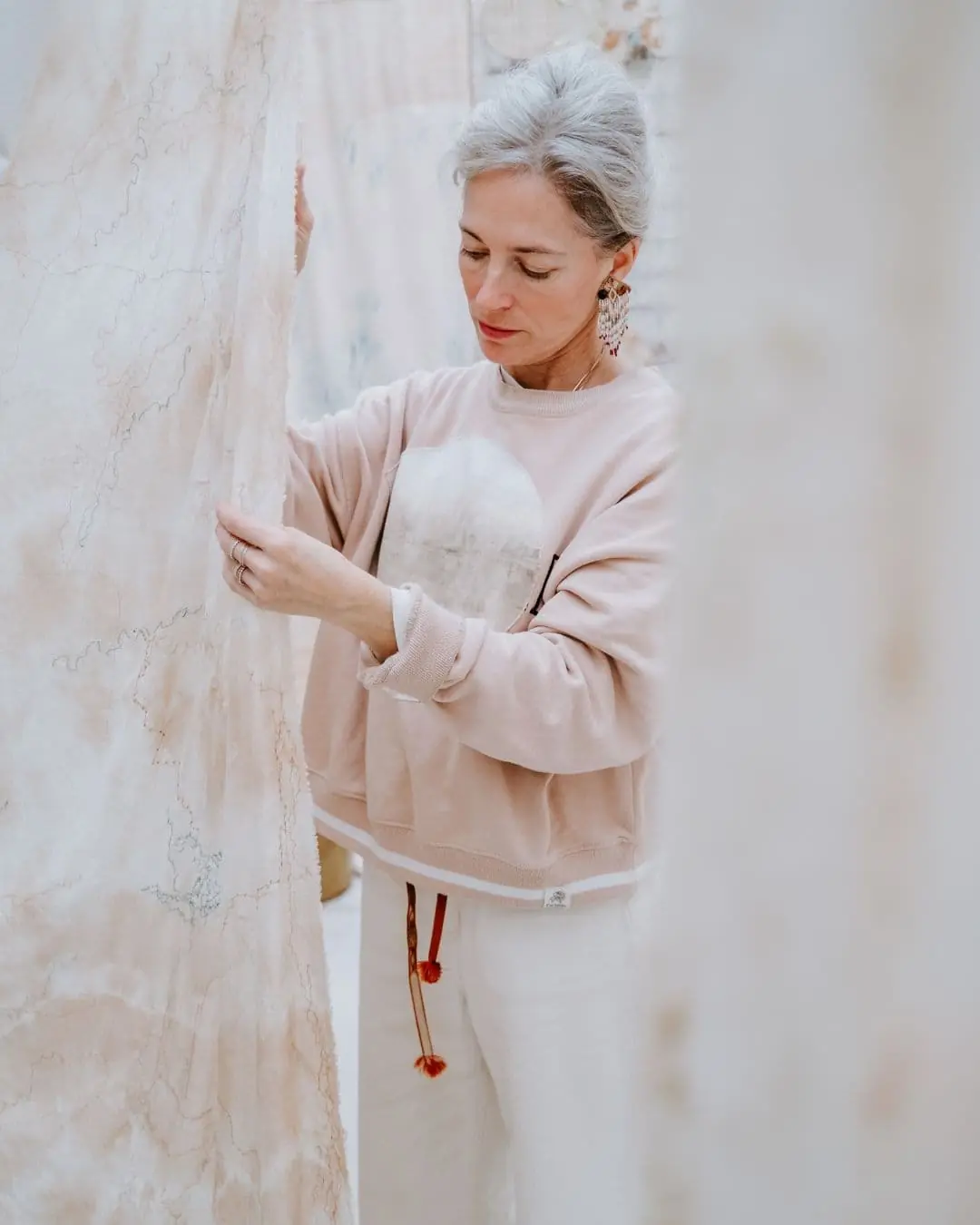 Textile artist Emma Cassi looking at a piece of fabric