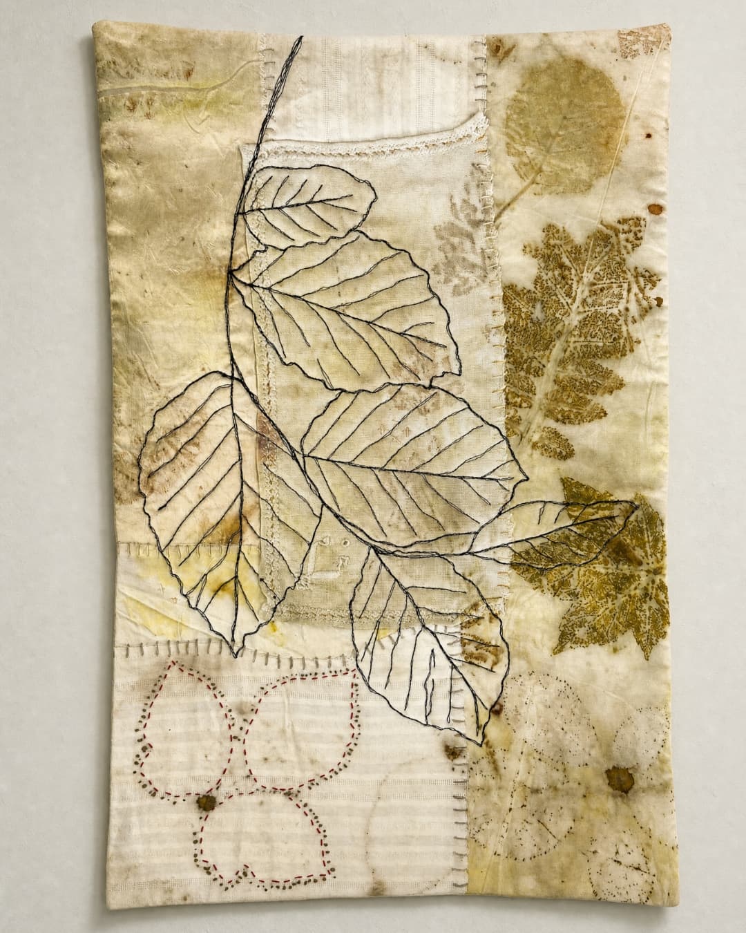 Textile art featuring stitched leaves.