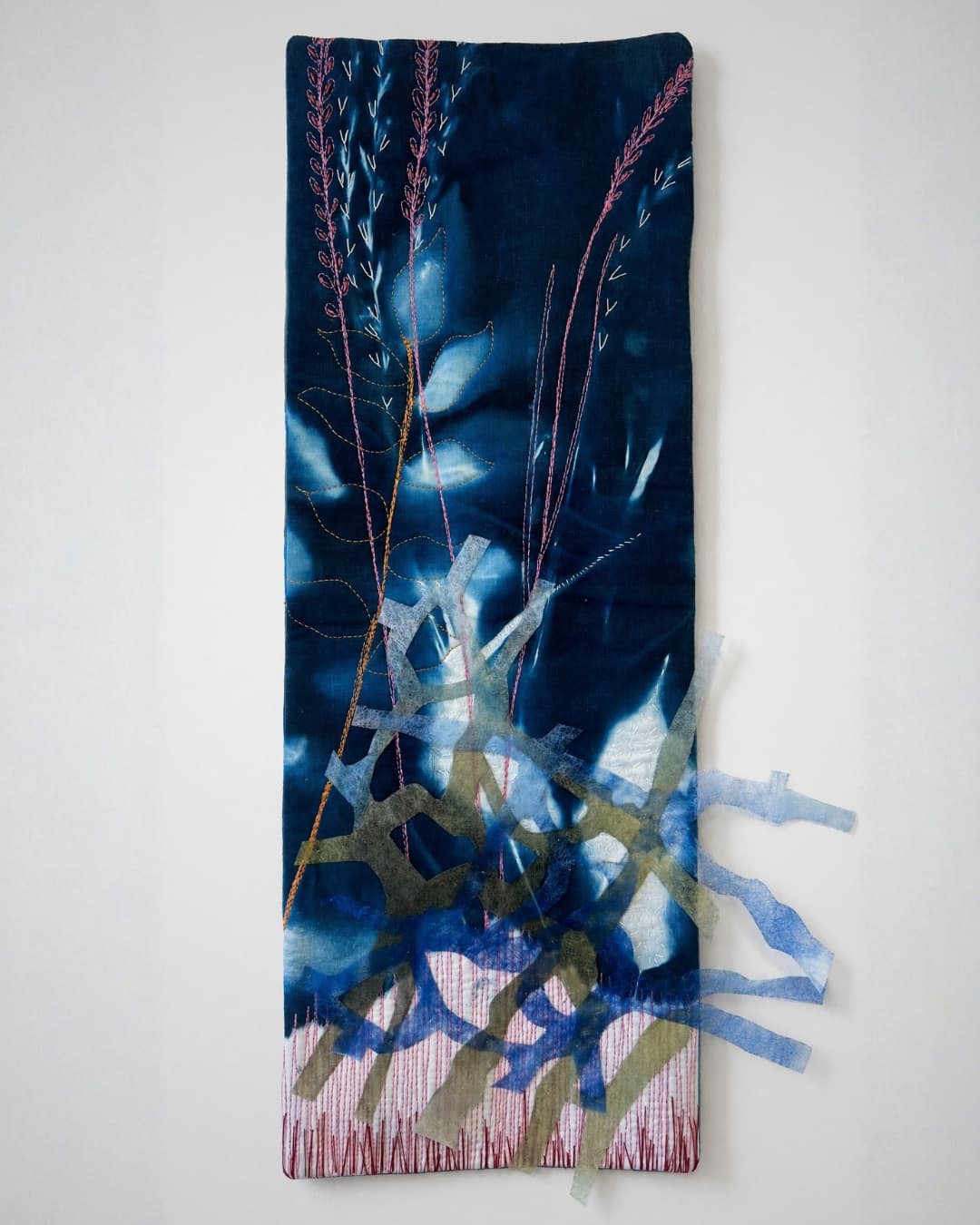 Textile artwork with botanical embroidery.