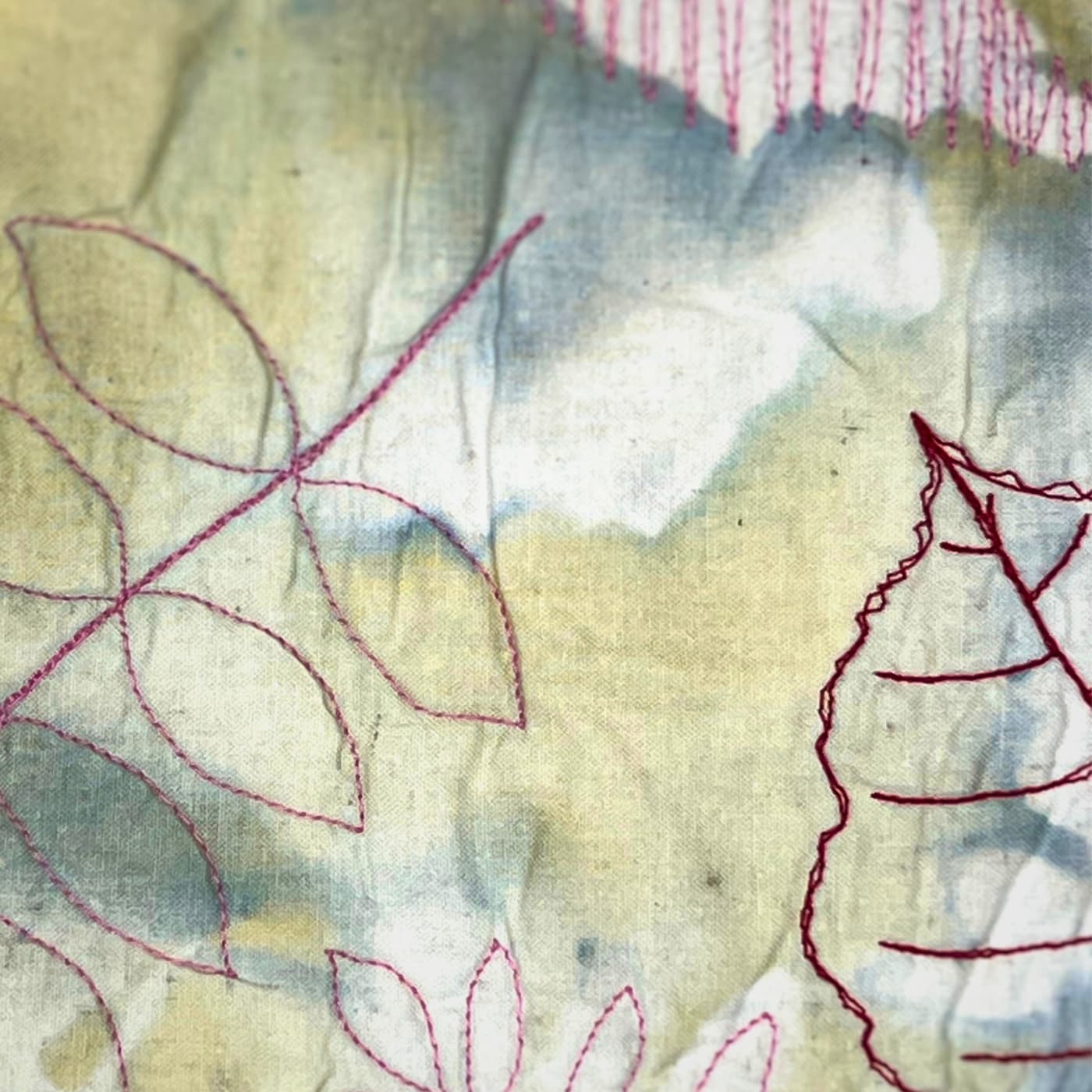 Textile with embroidered leaf patterns.