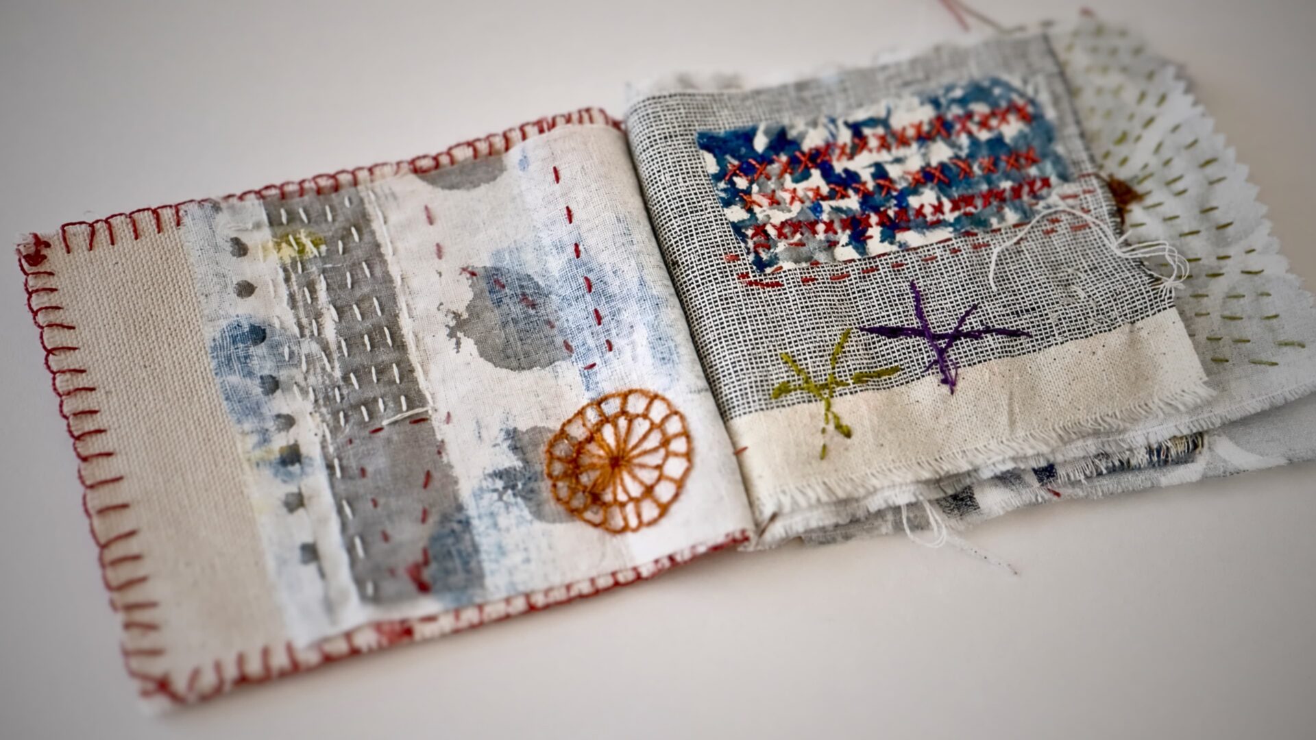 Textile art with colourful embroidery details.