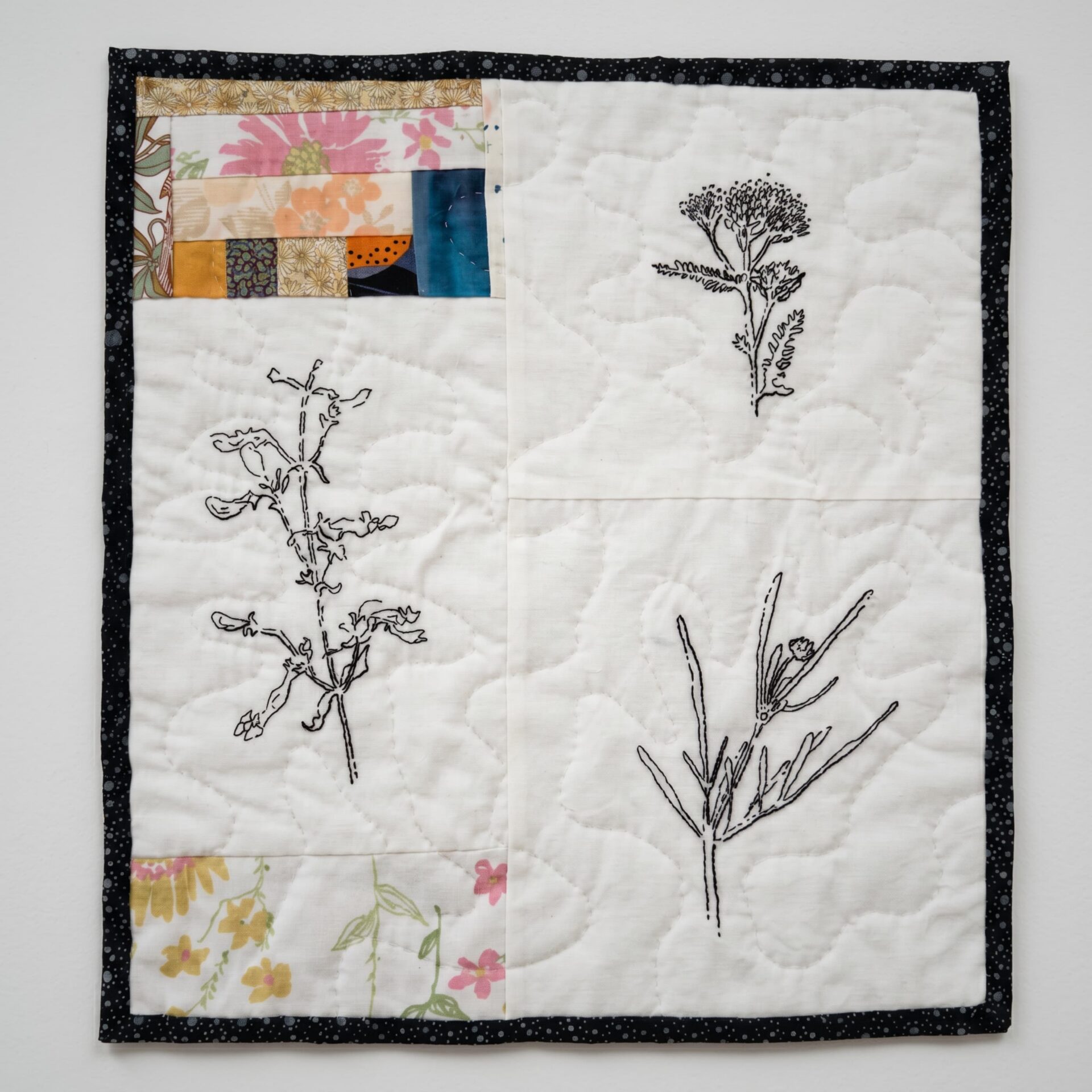 Quilt featuring botanical line drawings.
