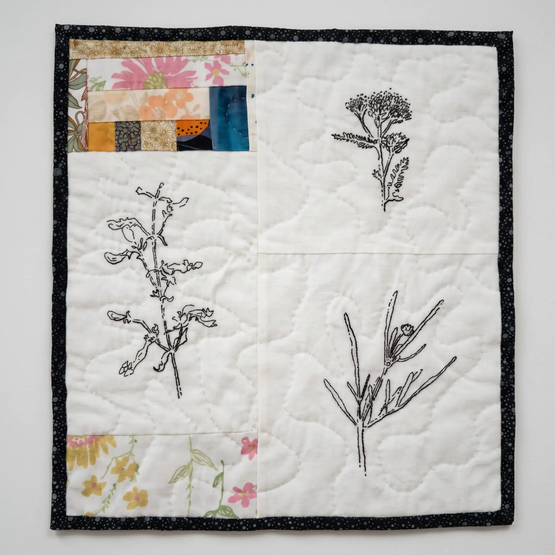 Quilt featuring botanical line drawings.