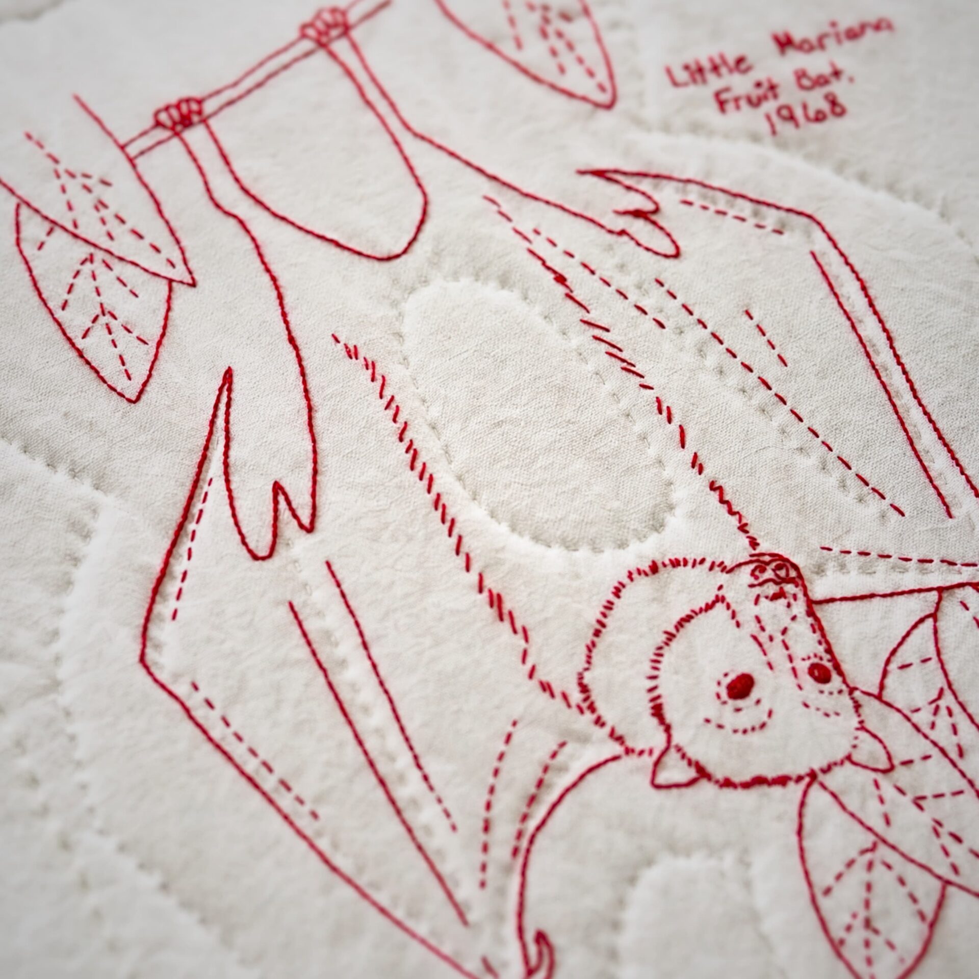 Red embroidered bat on fabric