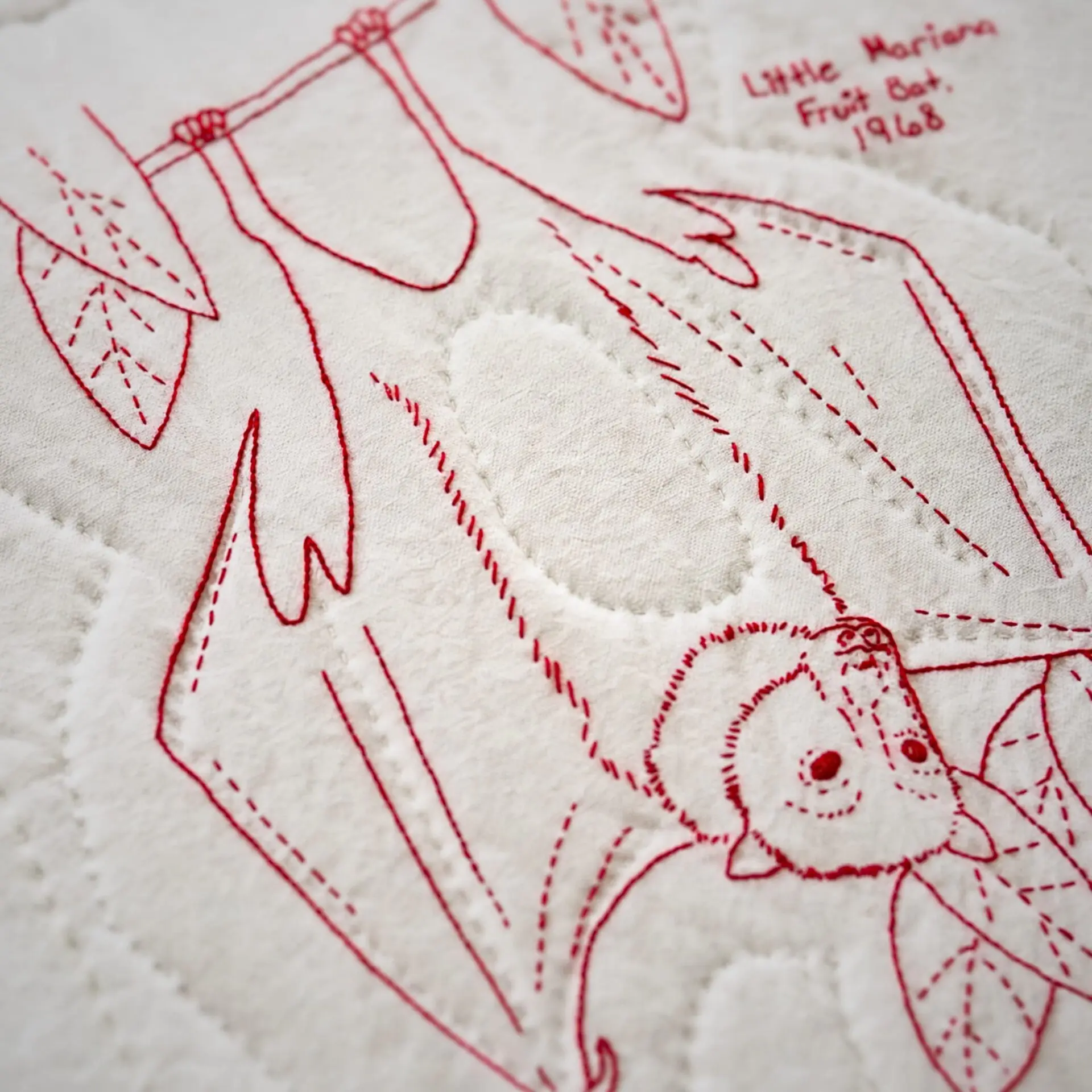 Red embroidered bat on fabric
