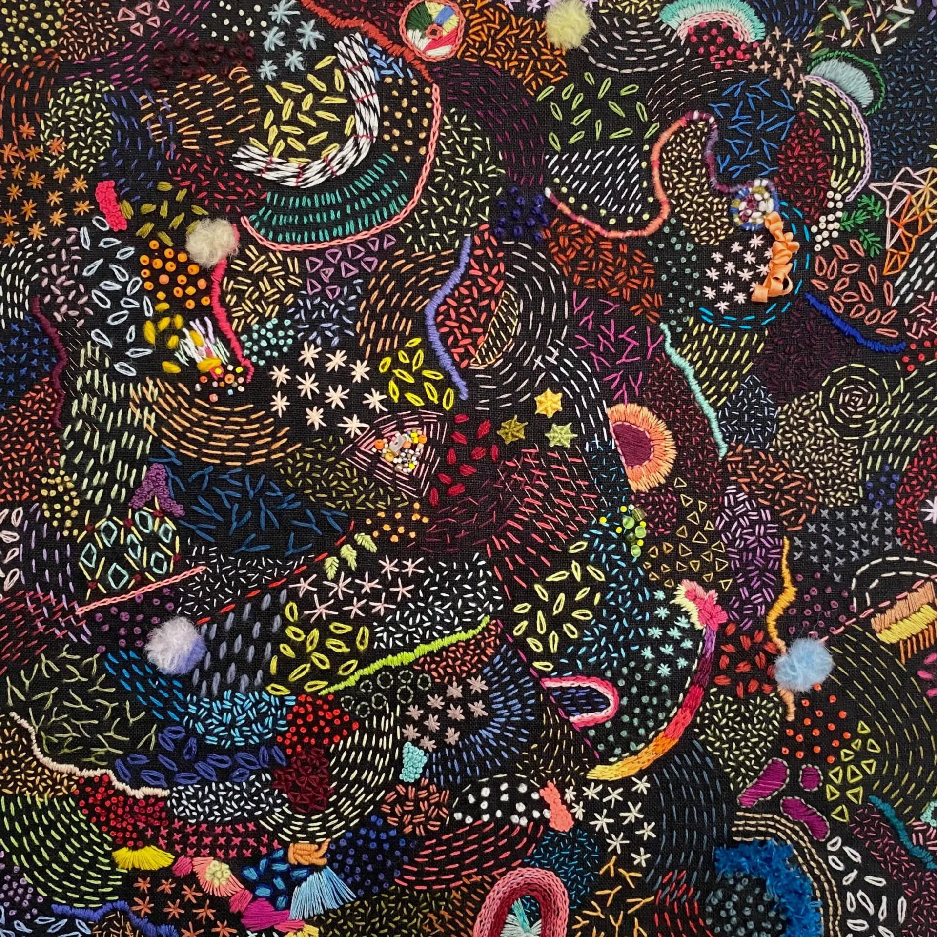 Vibrant abstract embroidery with intricate patterns.