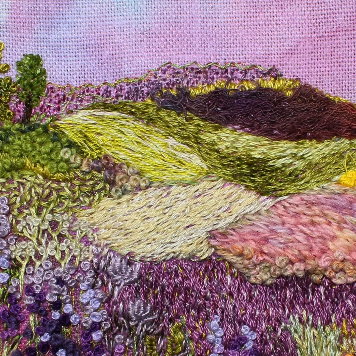 A close up of a stitched landscape of purple heather.
