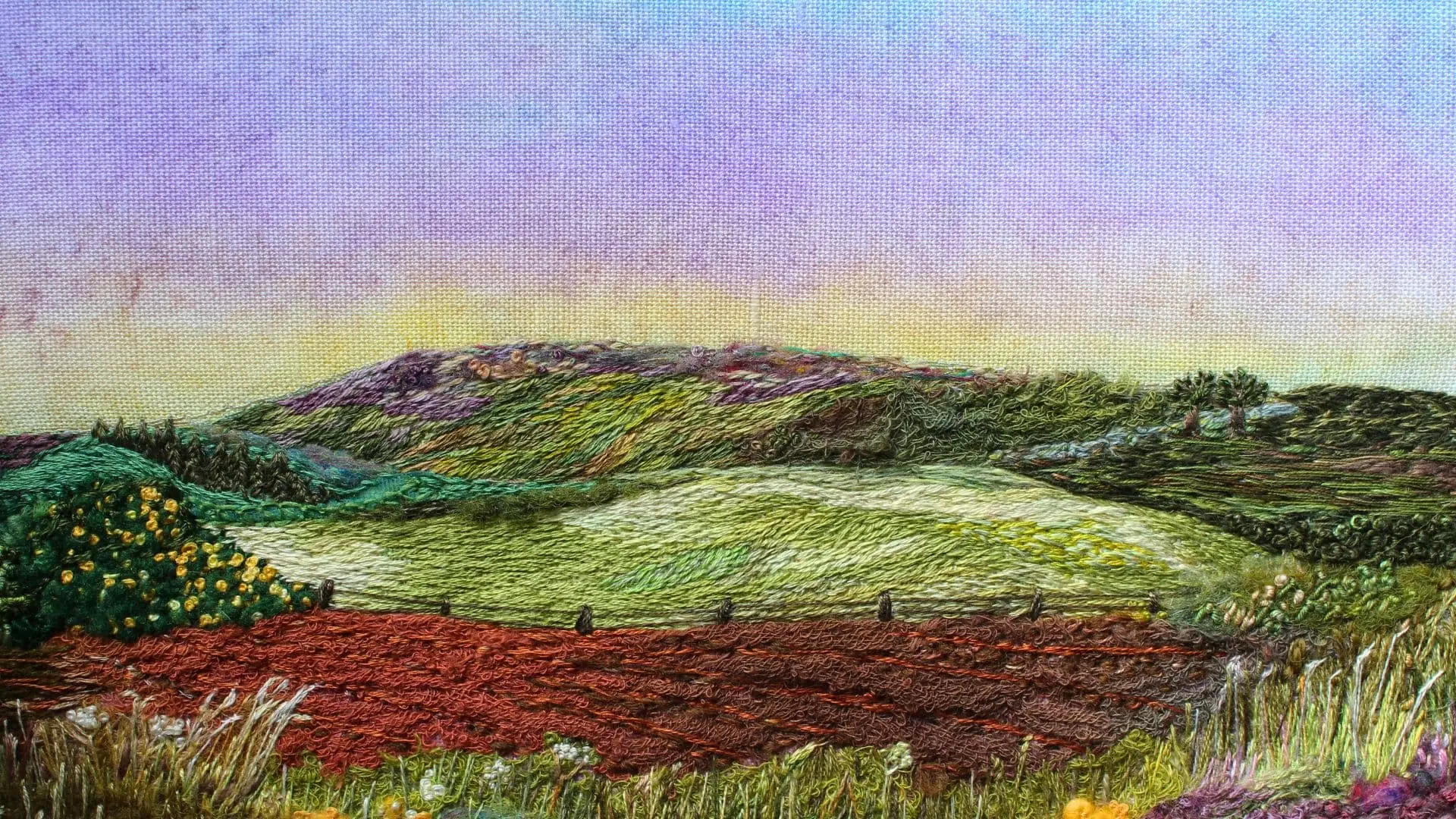 A stitched landscape of a field with hills and grass at dusk.