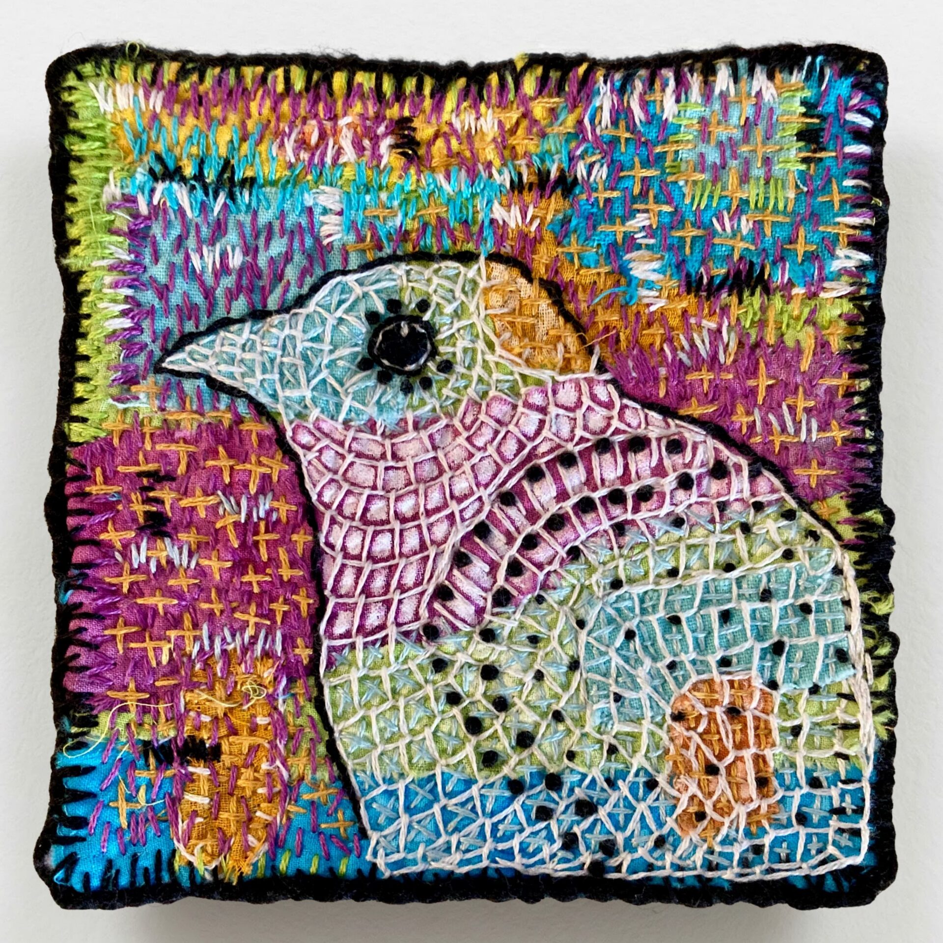 Colourful embroidered bird artwork