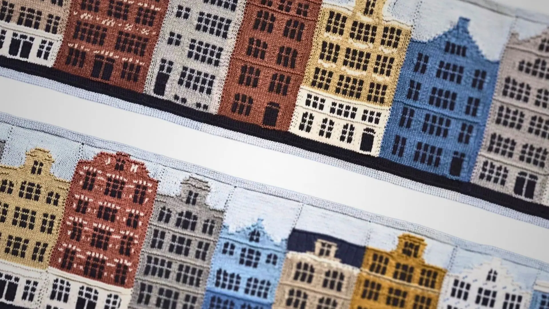 A knitted artwork with colourful buildings on it