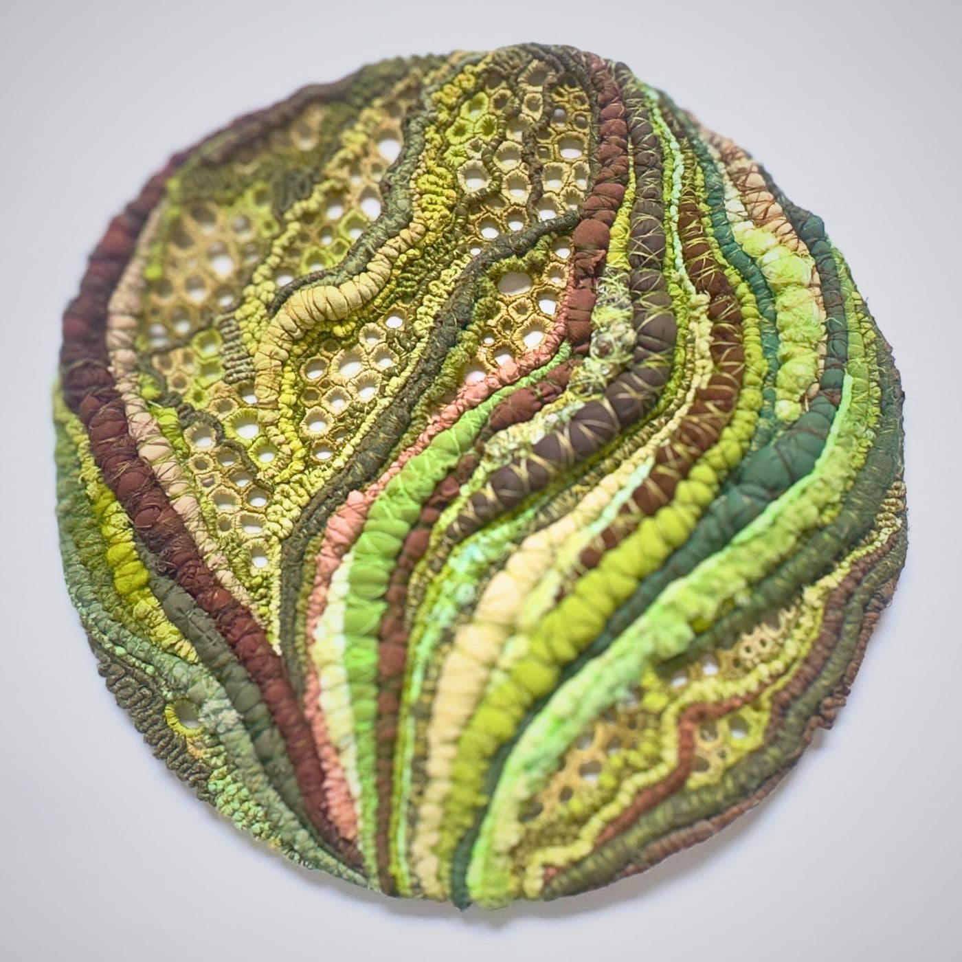 A close up of an embroidered multi thread fabric