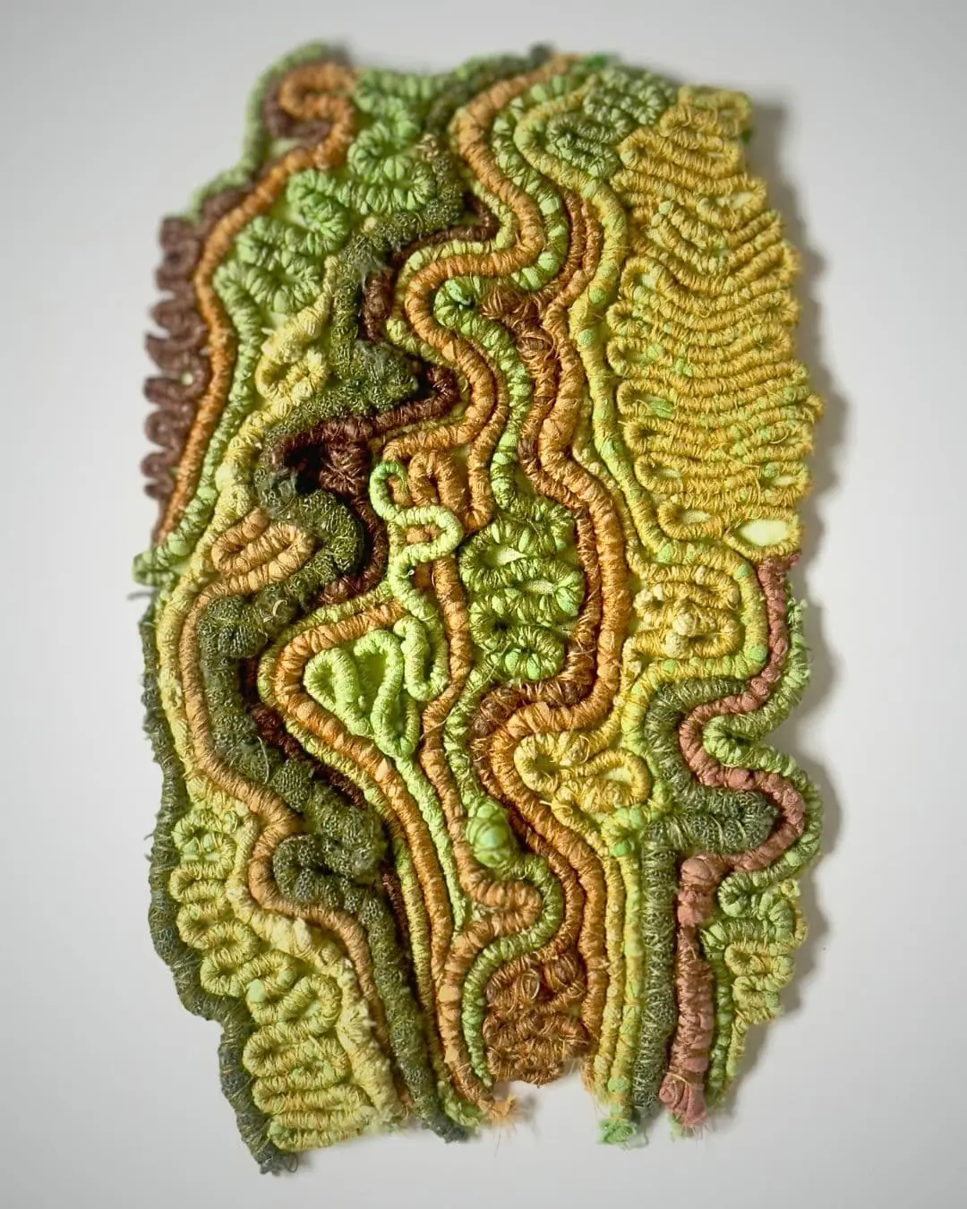A spring greens artwork using various techniques with cotton.