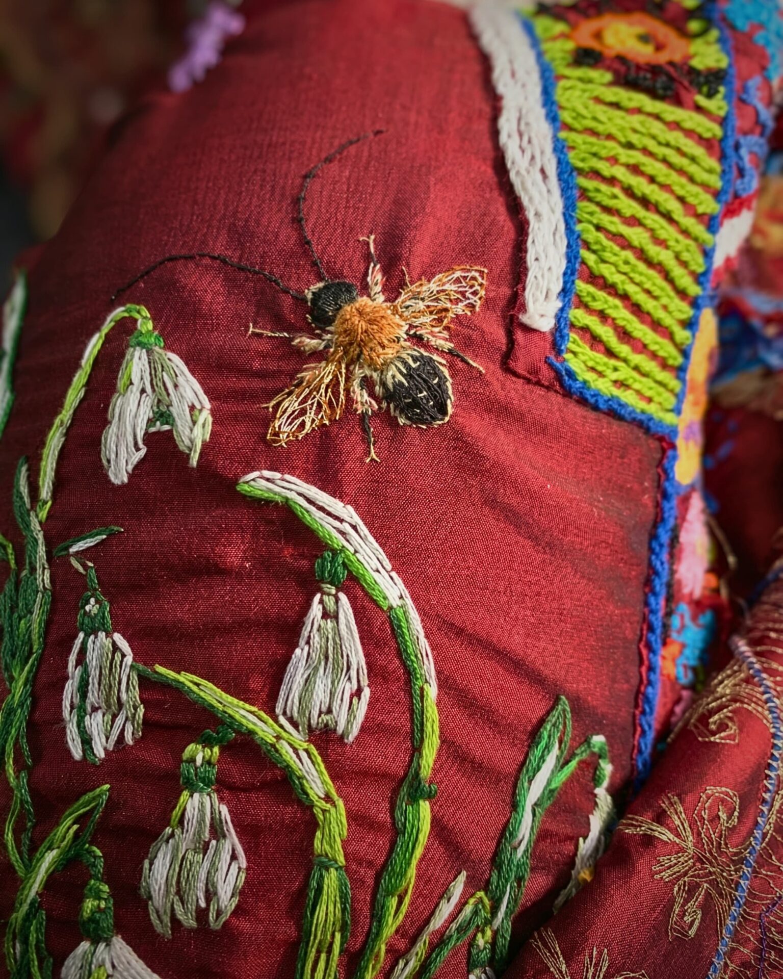 Intricate embroidery of a bee and floral design