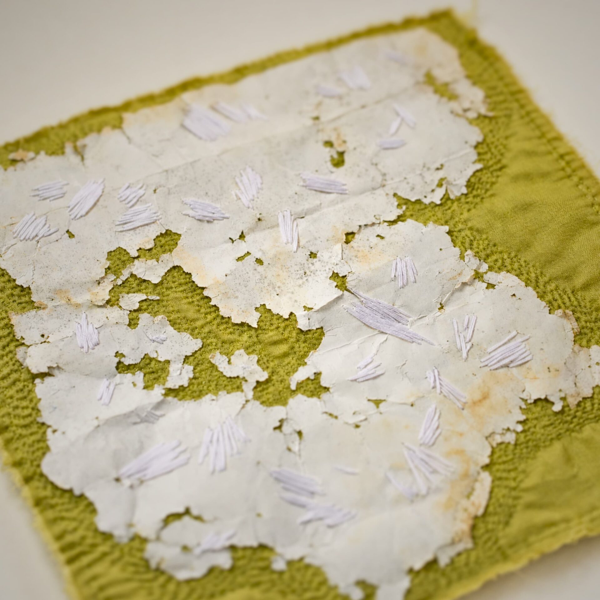 Textured fabric with white stitching details.