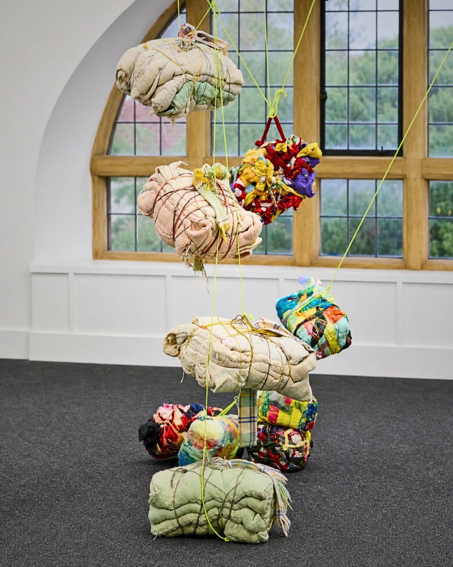 Colourful fabric bundles suspended artistically.