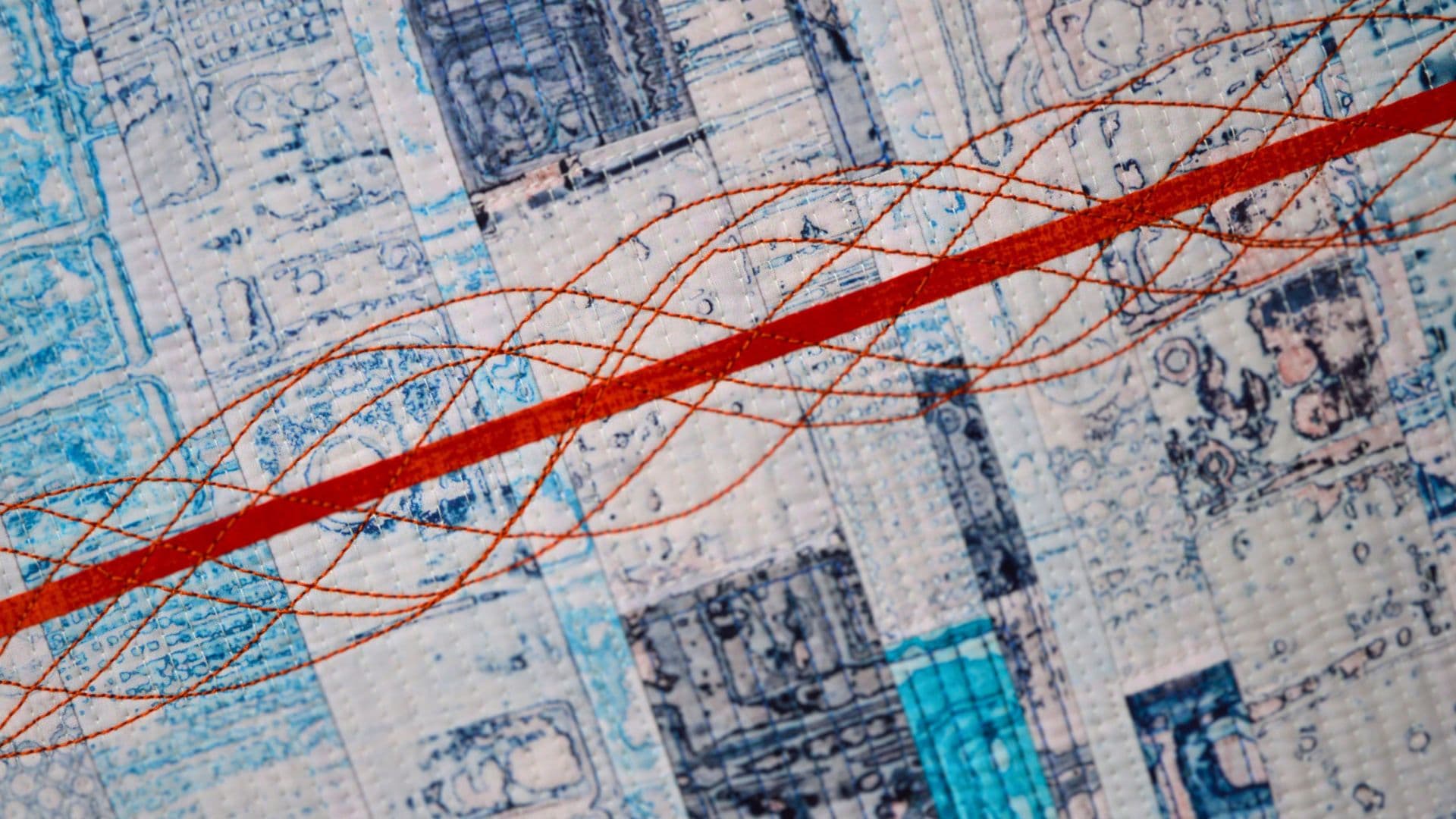 close up of a quilt with red line and blue detail on cotton fabric