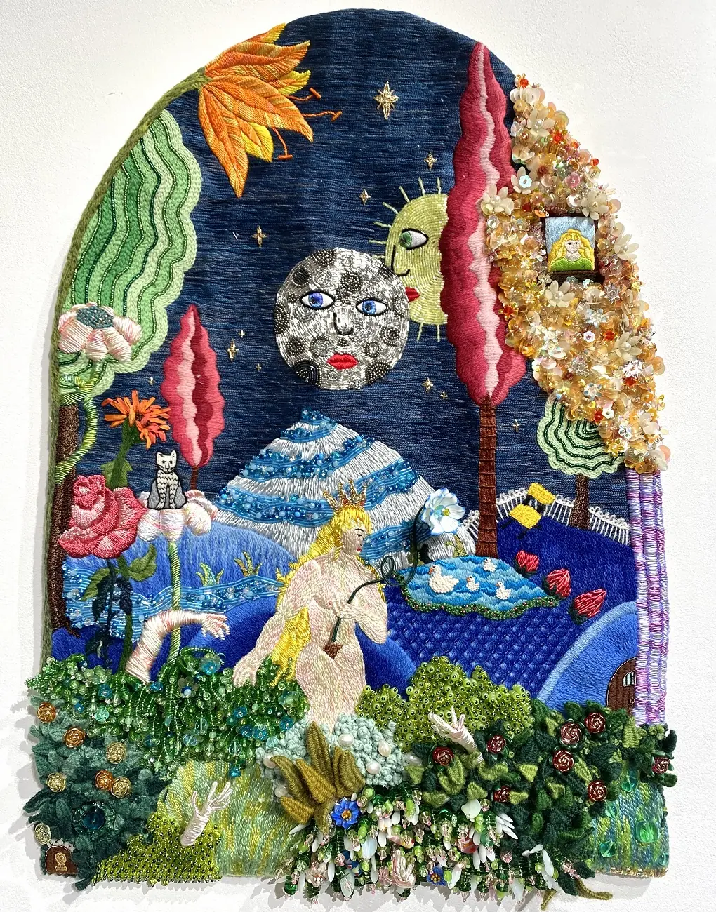 Mixed media textile art work of a naked lady amongst flowers mountains and the moon
