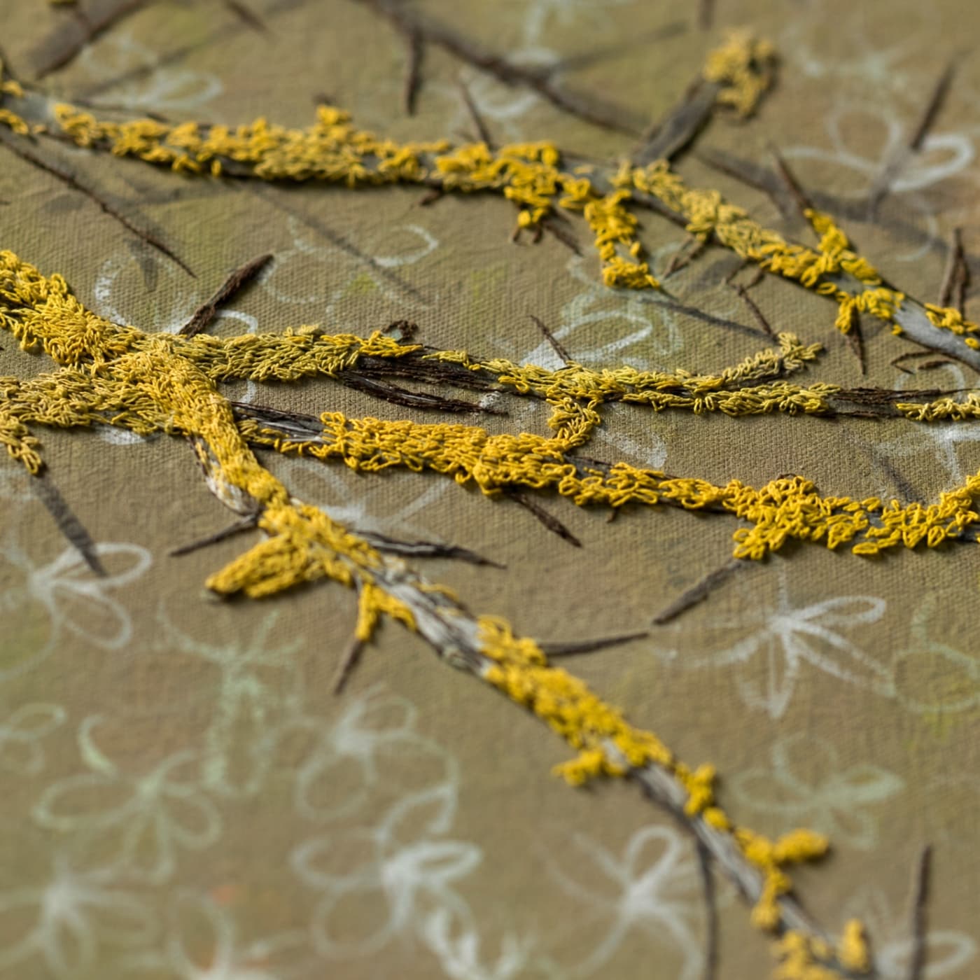 Detail image of textile textured yellow branches on patterned background