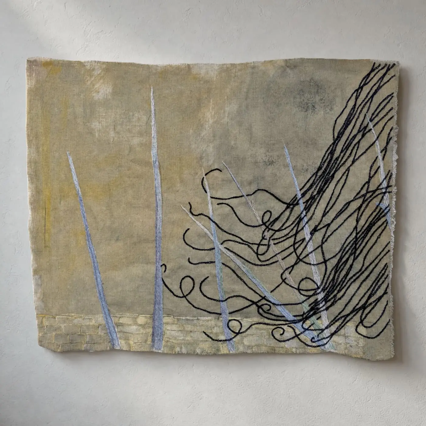 Abstract textile artwork with swirling lines and textures.