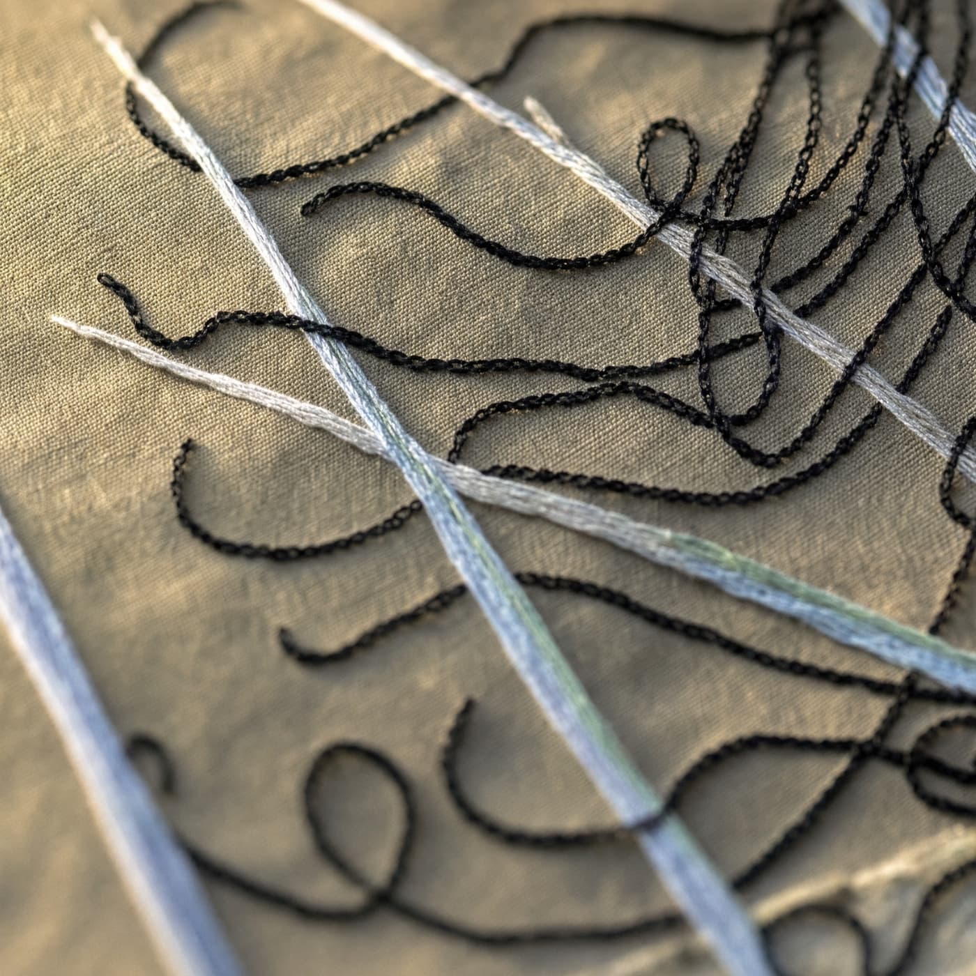 Intricate threads on textured fabric surface.