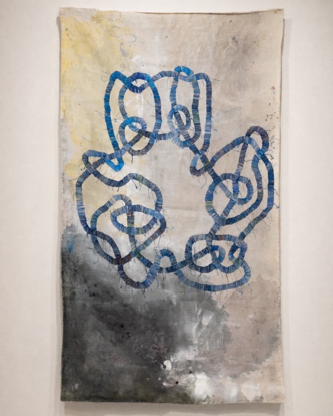 Abstract fabric artwork with blue knots.