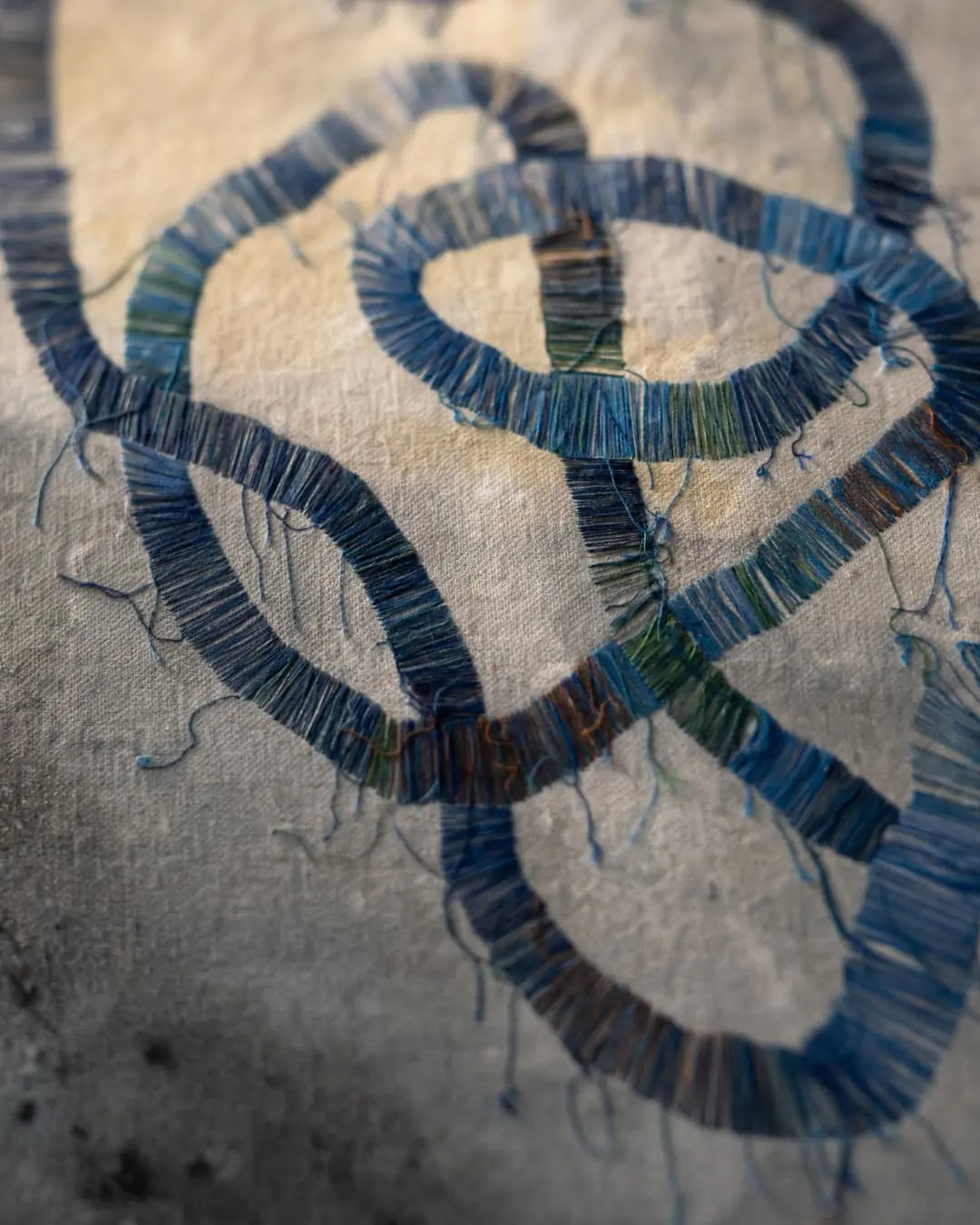 Intricate blue thread loops on fabric.