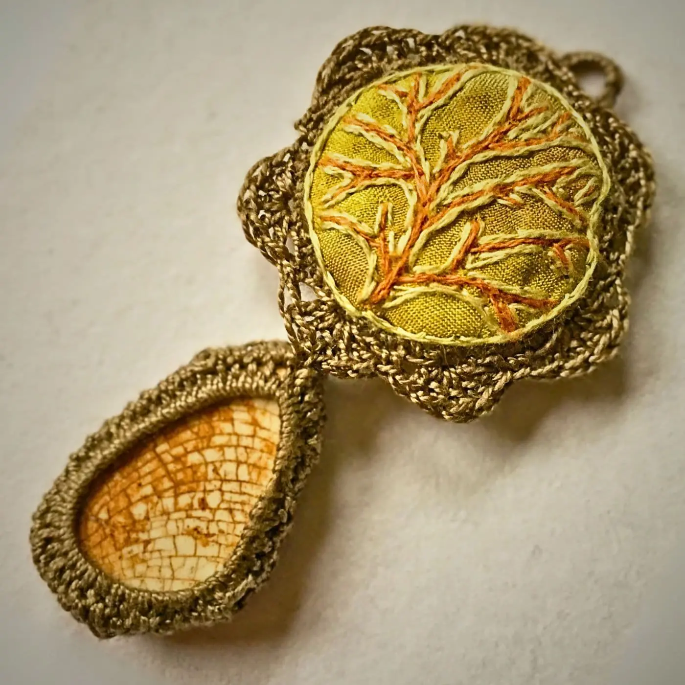 A close up of an embroidered pendant