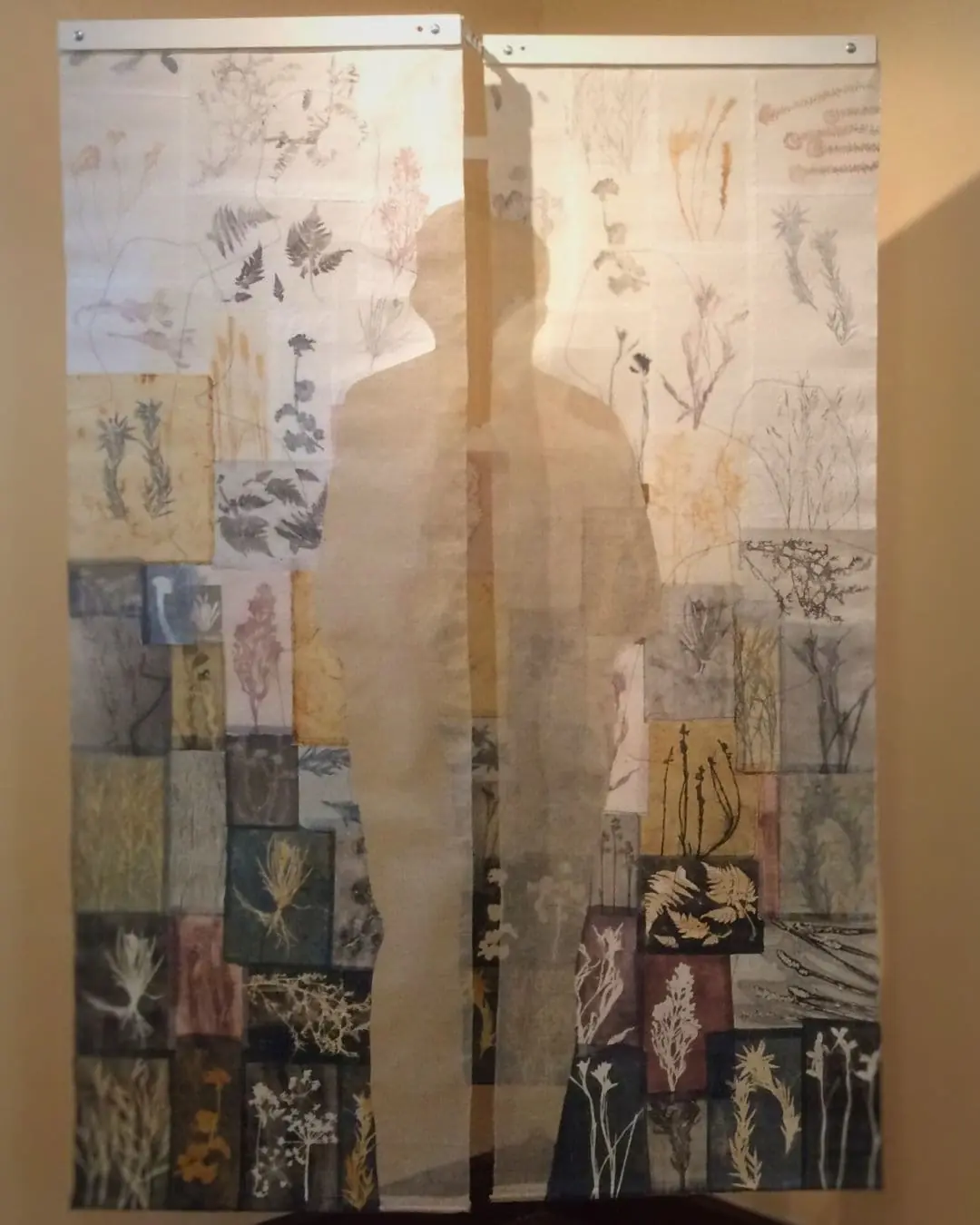 A hanging piece of textile art with silhouette of a person