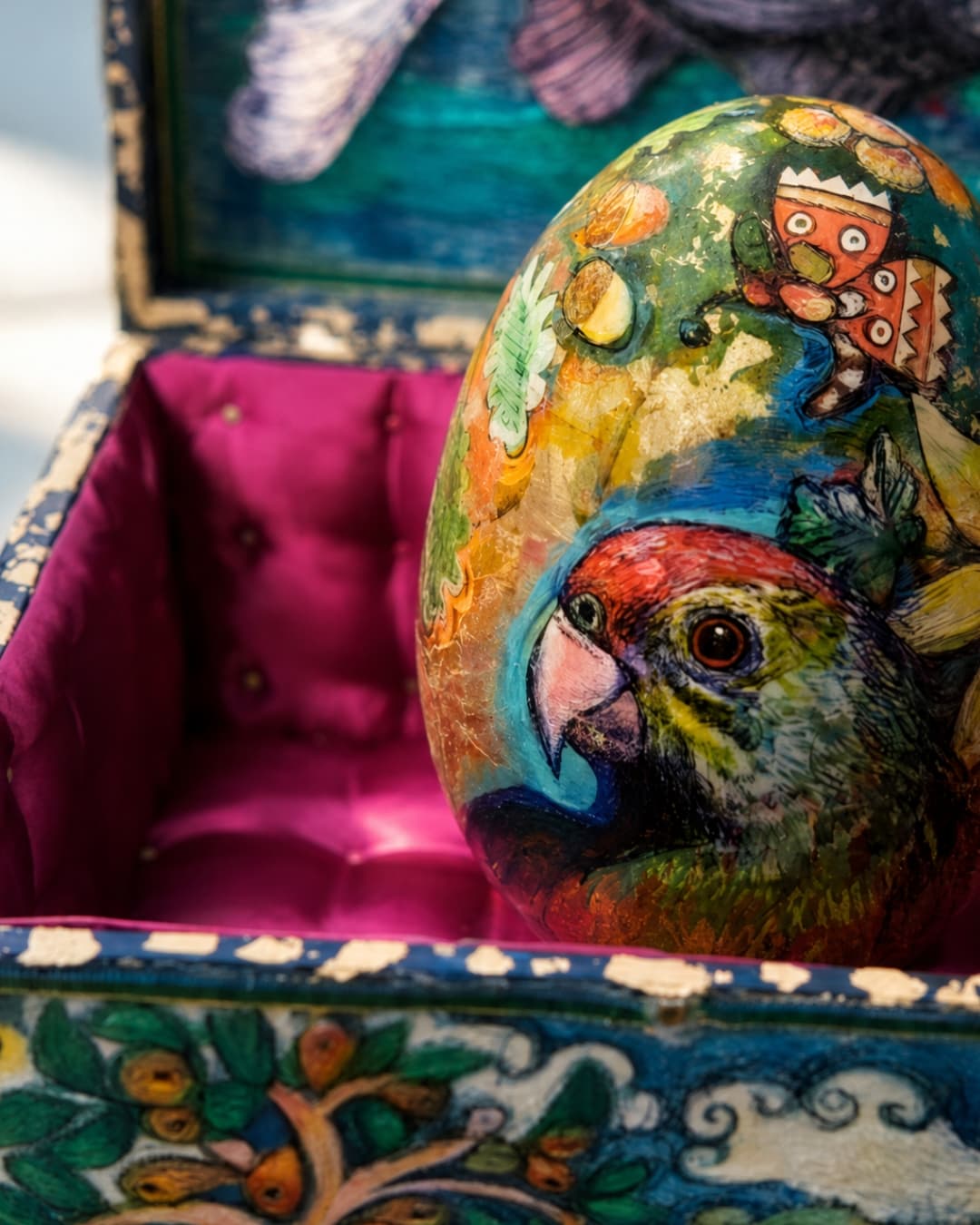 Colourful egg inside ornate casket.