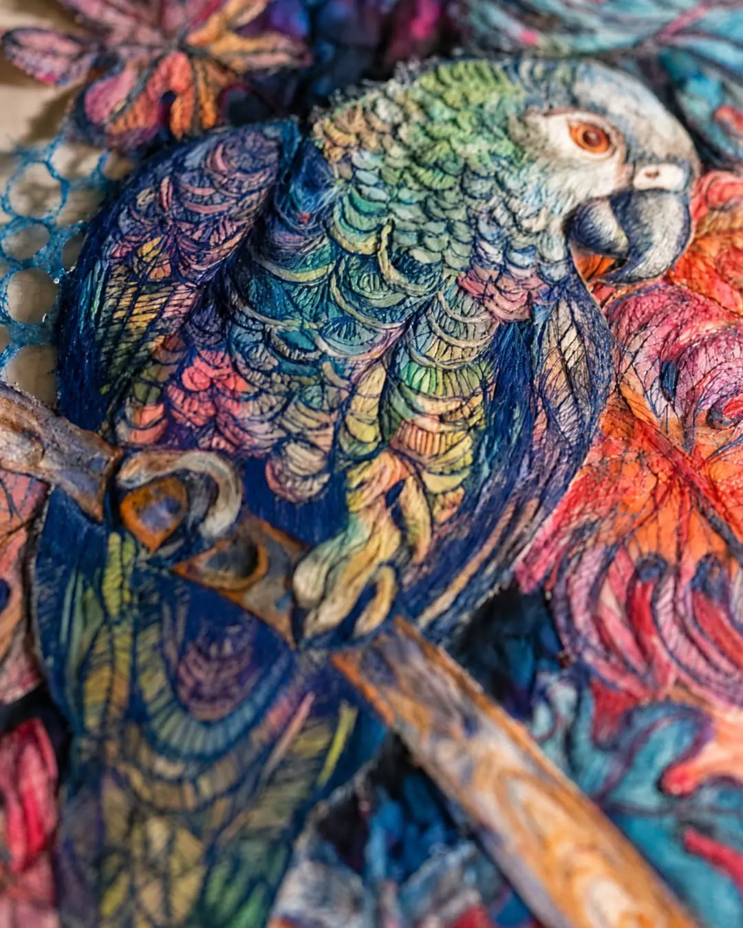Colourful embroidered parrot on fabric.