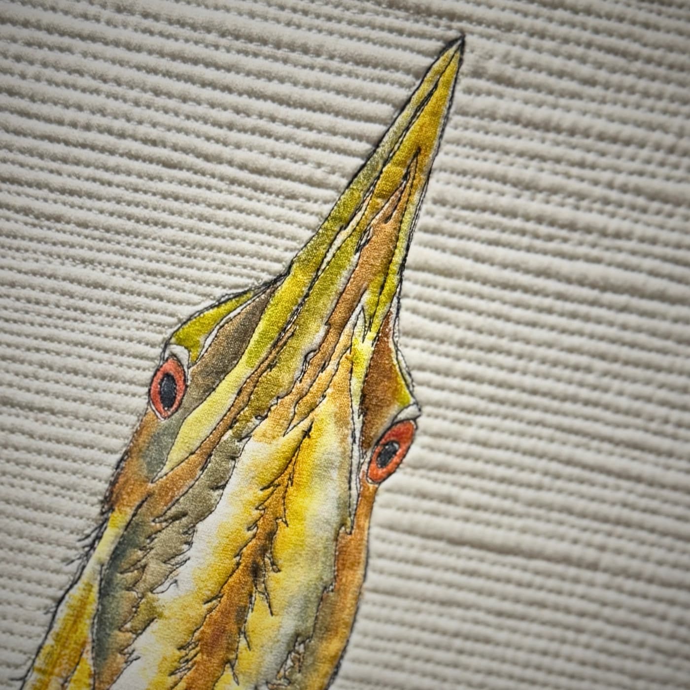 A close up of a bird's face stitched