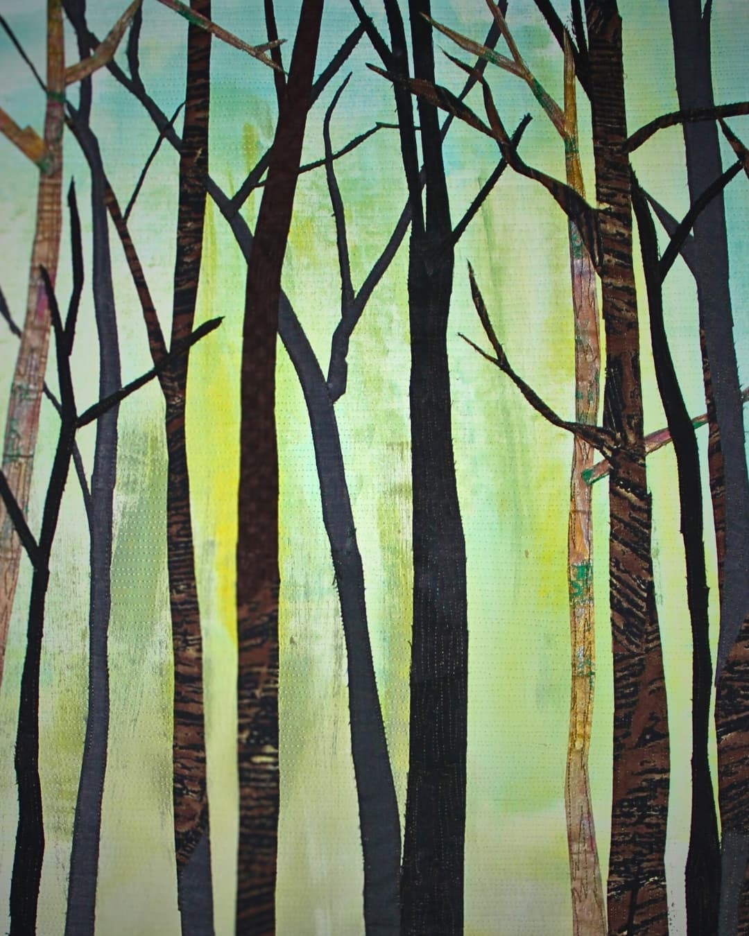 A stitched artwork of trees in the woods