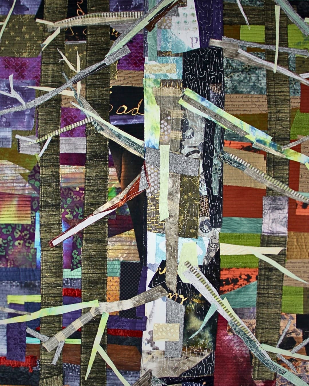 A stitched piece of art with a tree made of patched fabric and stitch