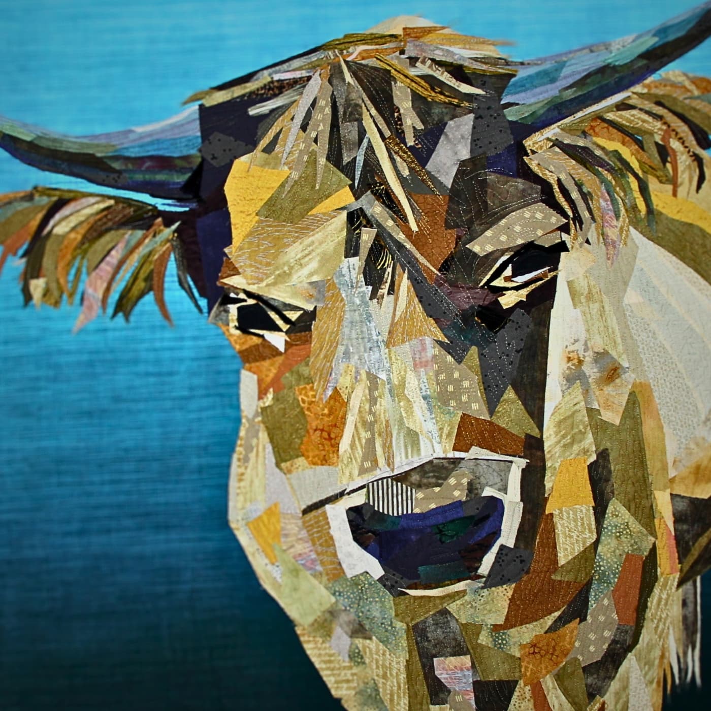 A stitched art piece, close up of a cow made out of pieces of fabric