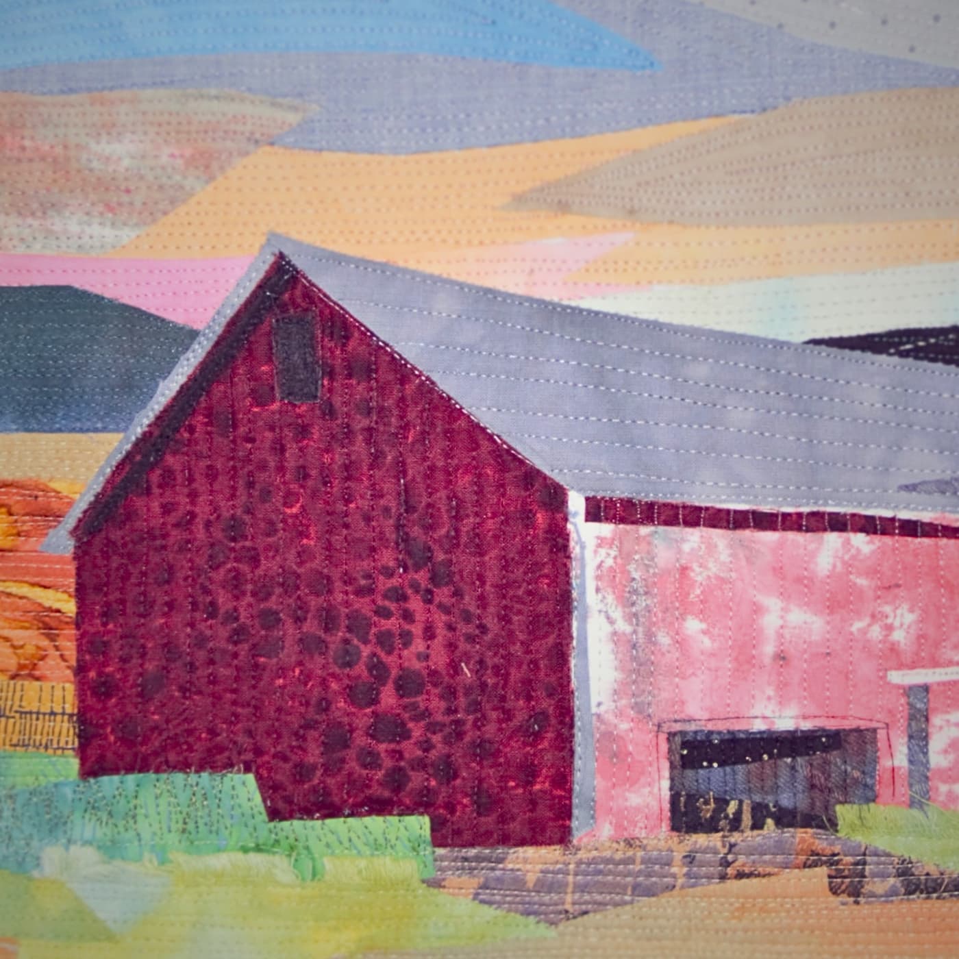 A stitched artwork of a red barn