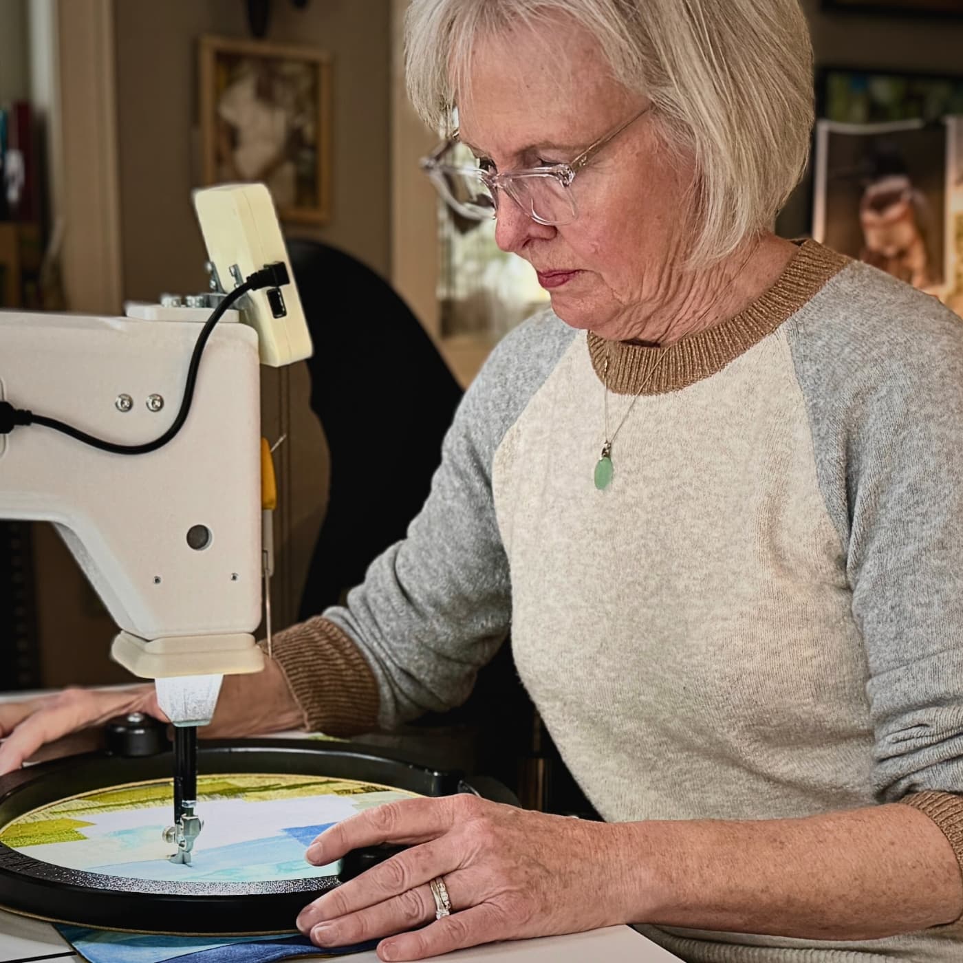 Textile Artist Pat Baum Bishop working in her studio at her sewing machine