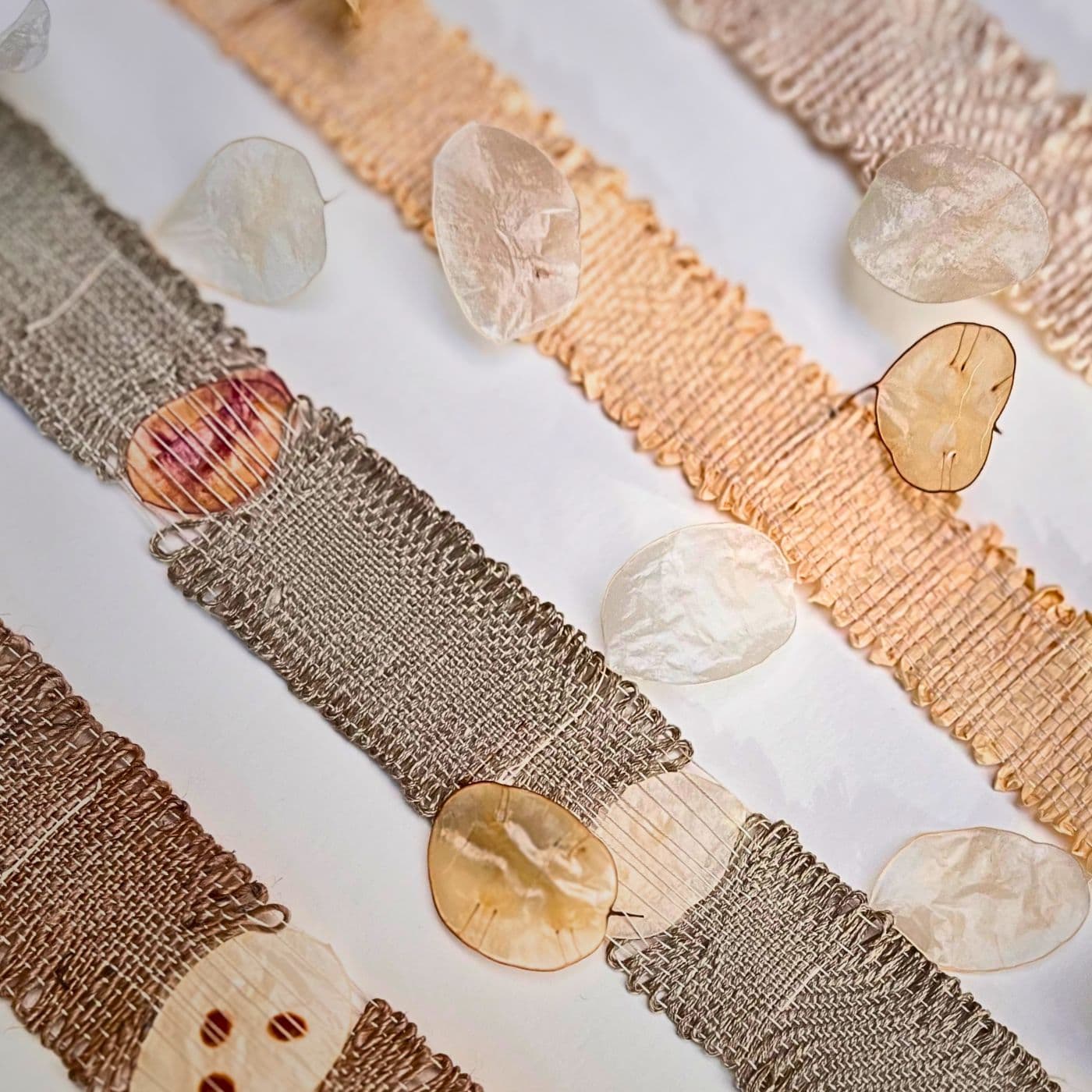 Textured fabric artwork with natural elements.