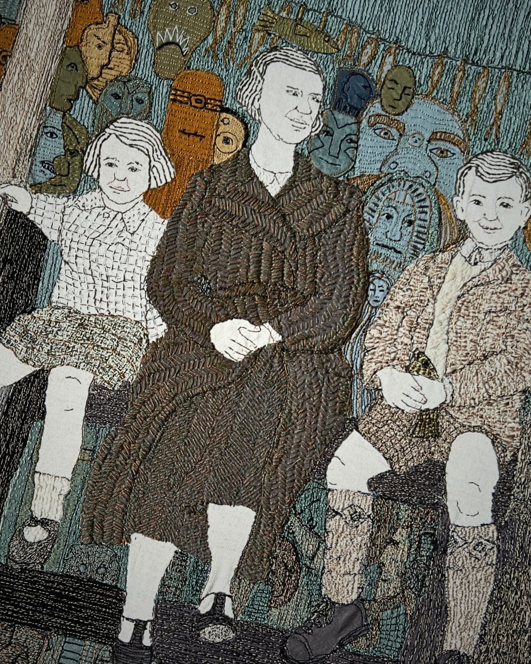 Three figures seated with artistic background.