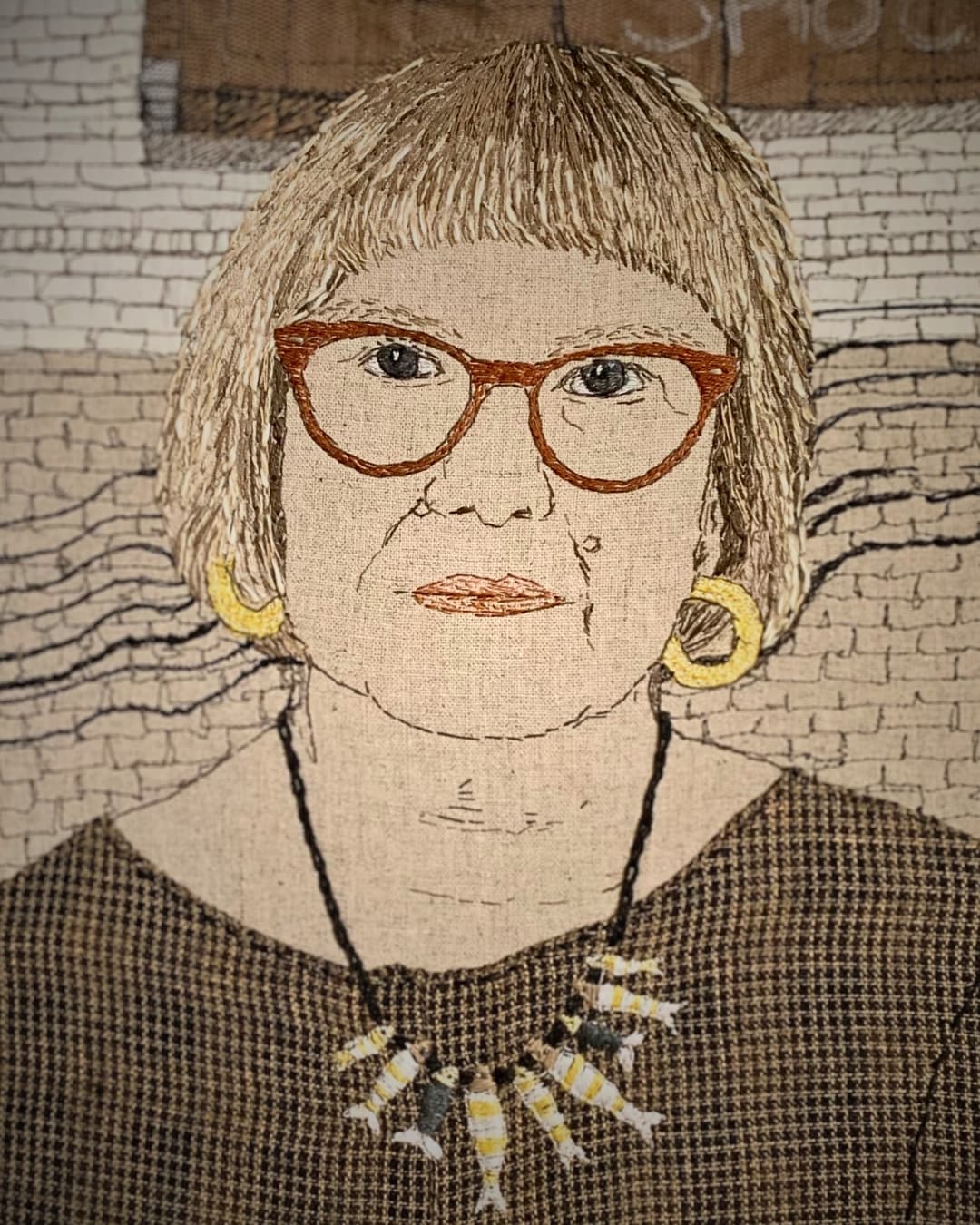 Artistic textile self-portrait with necklace detail.