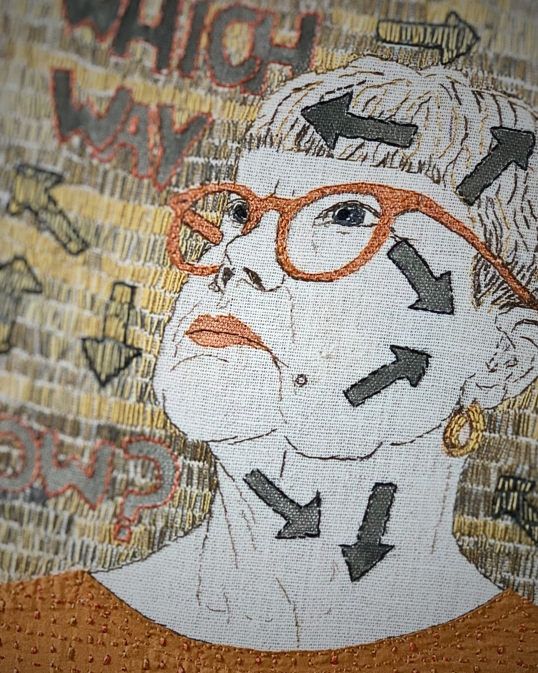 Textile portrait of a artist Sue Stone with arrows.