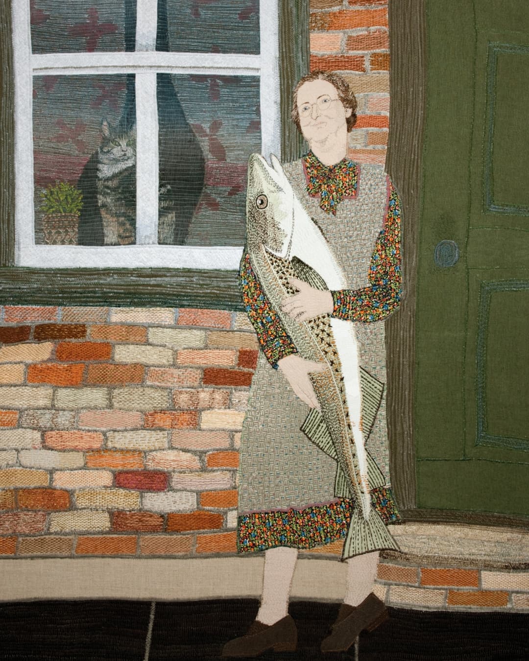 Embroidered art piece of a woman holding large fish outside house.