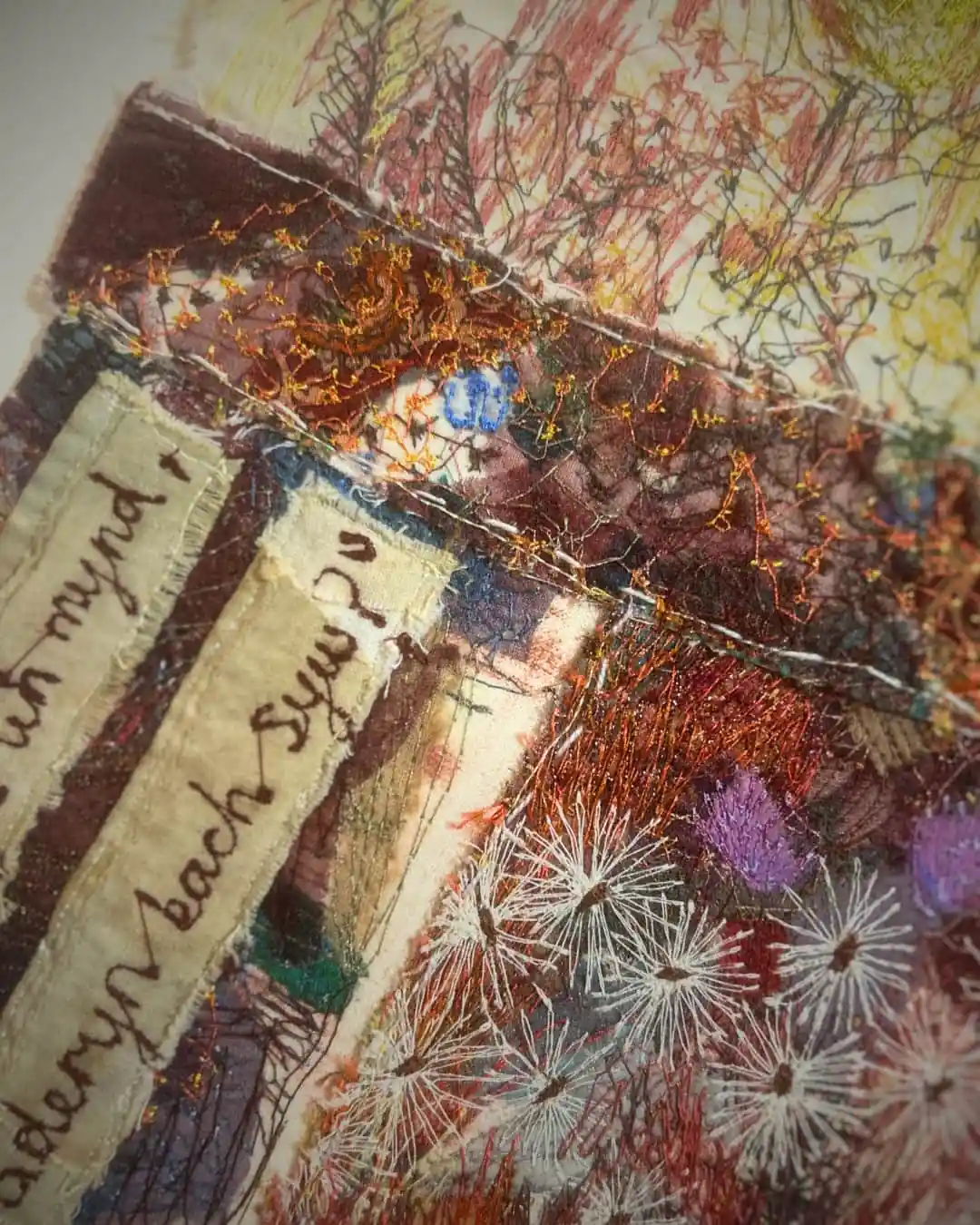Colourful textile art with intricate stitching.