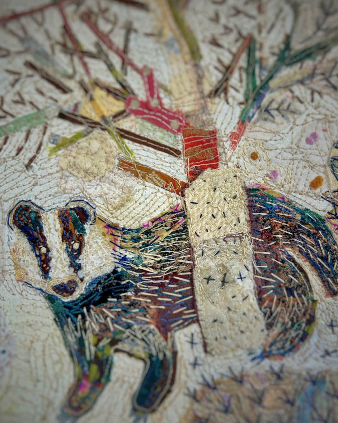 Colourful embroidered badger near tree