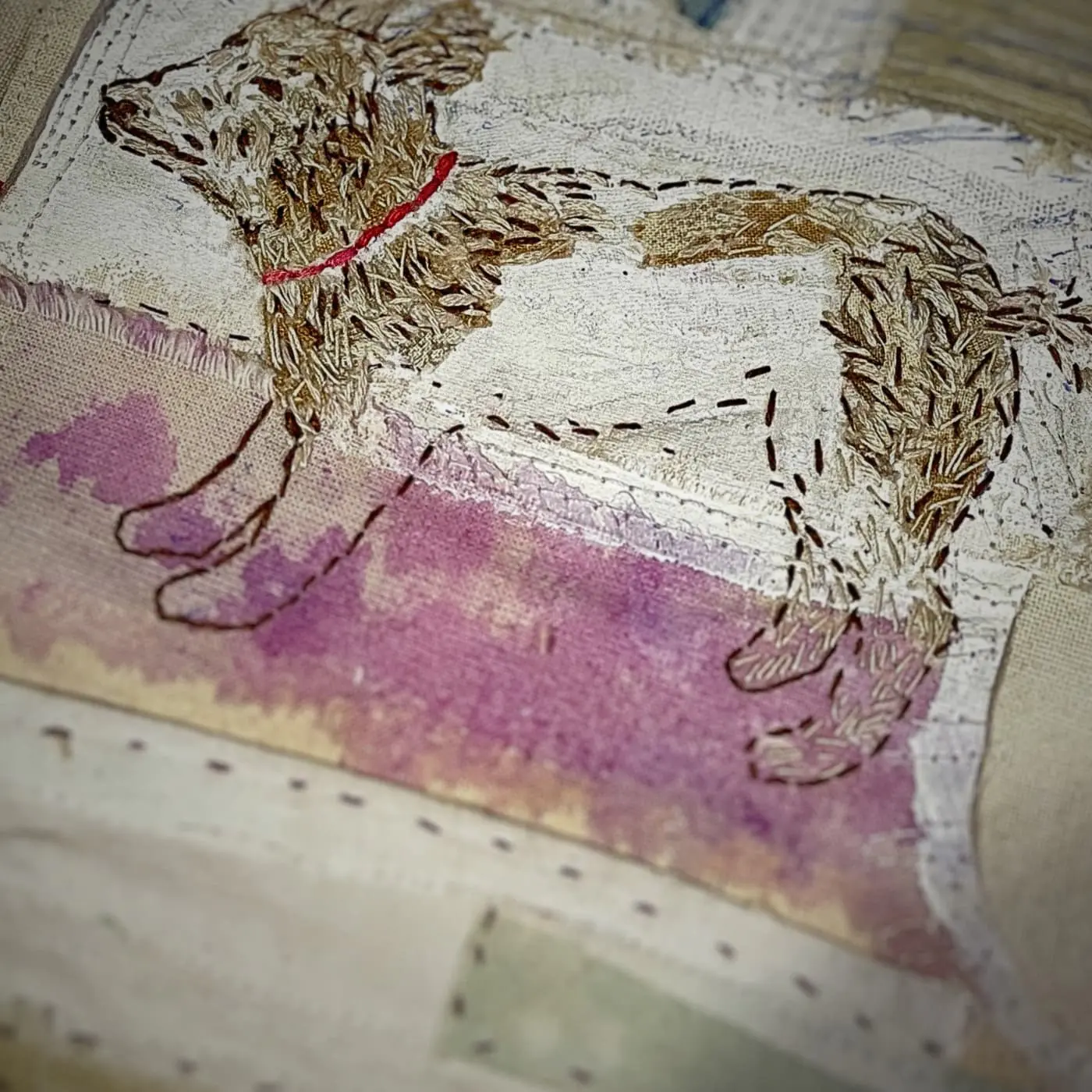 Embroidered dog on fabric background.