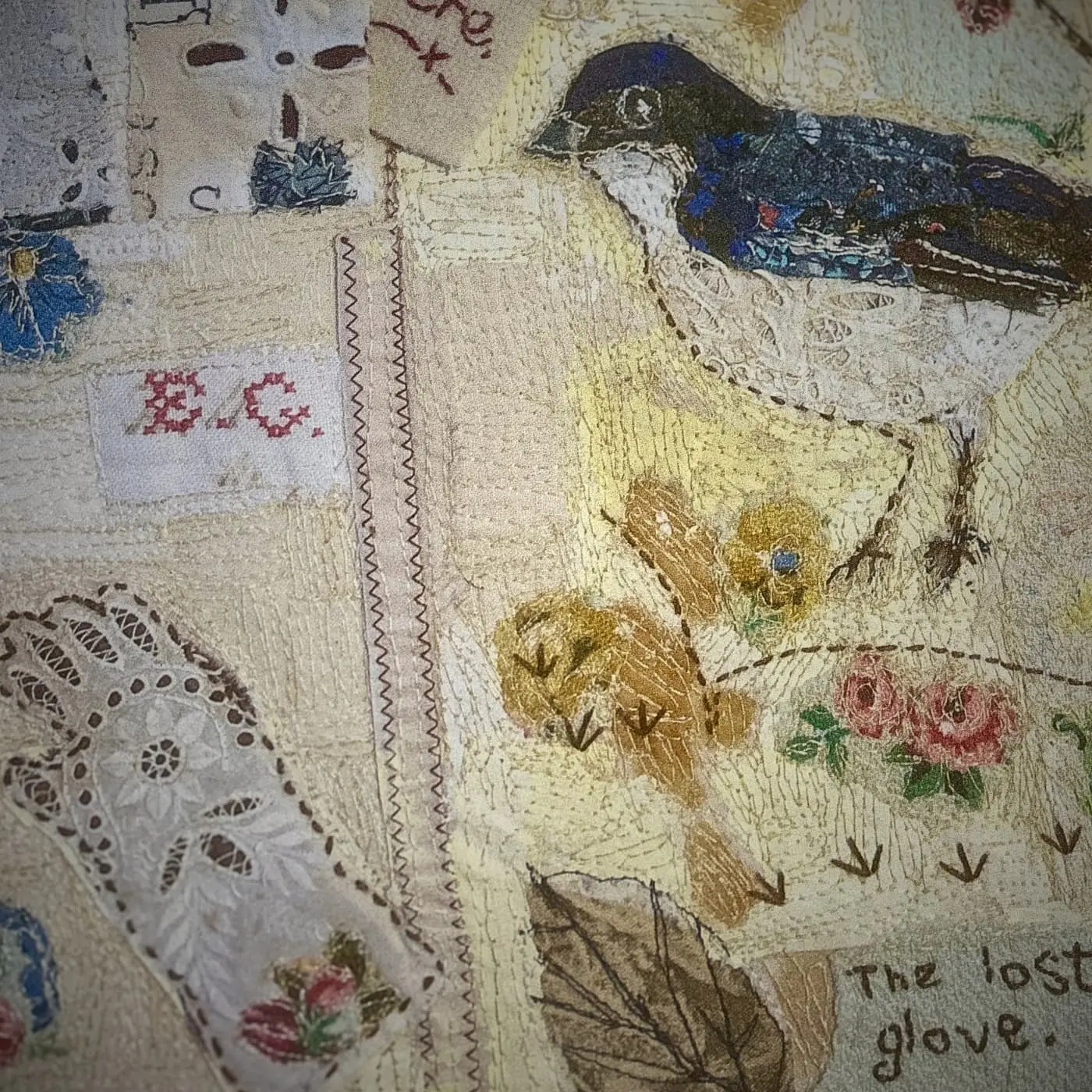 Colourful textile art featuring a bird on collaged embroidered background.