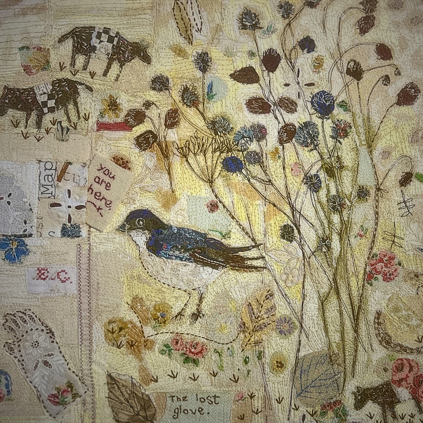 Bird and flowers in textile art with embroidered background and collage.