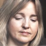 Close-up portrait of Yvette Phillips, a textile artist, deeply engaged in her creative work, showcasing her concentration